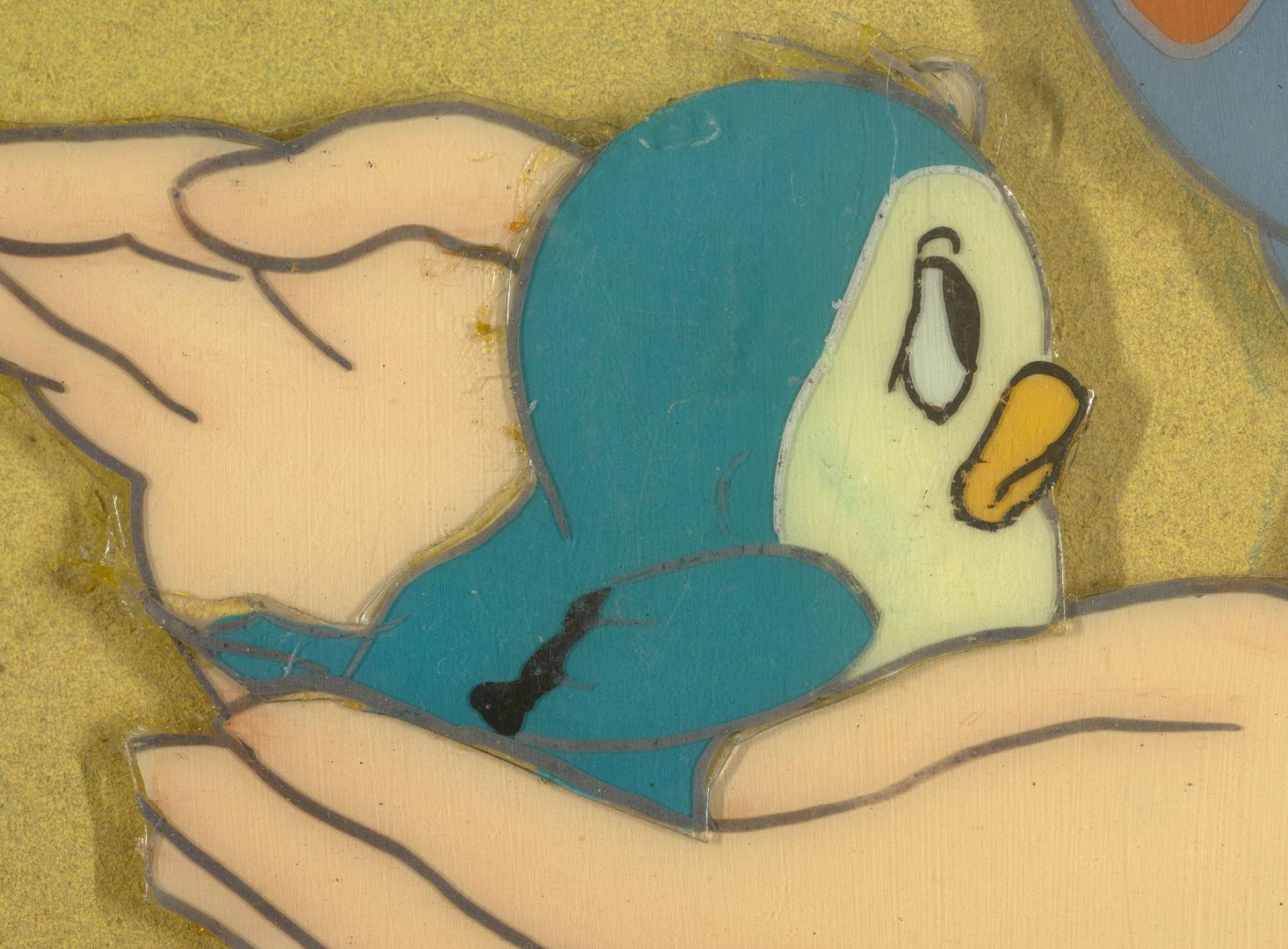 An image of two hands holding a blue bird.