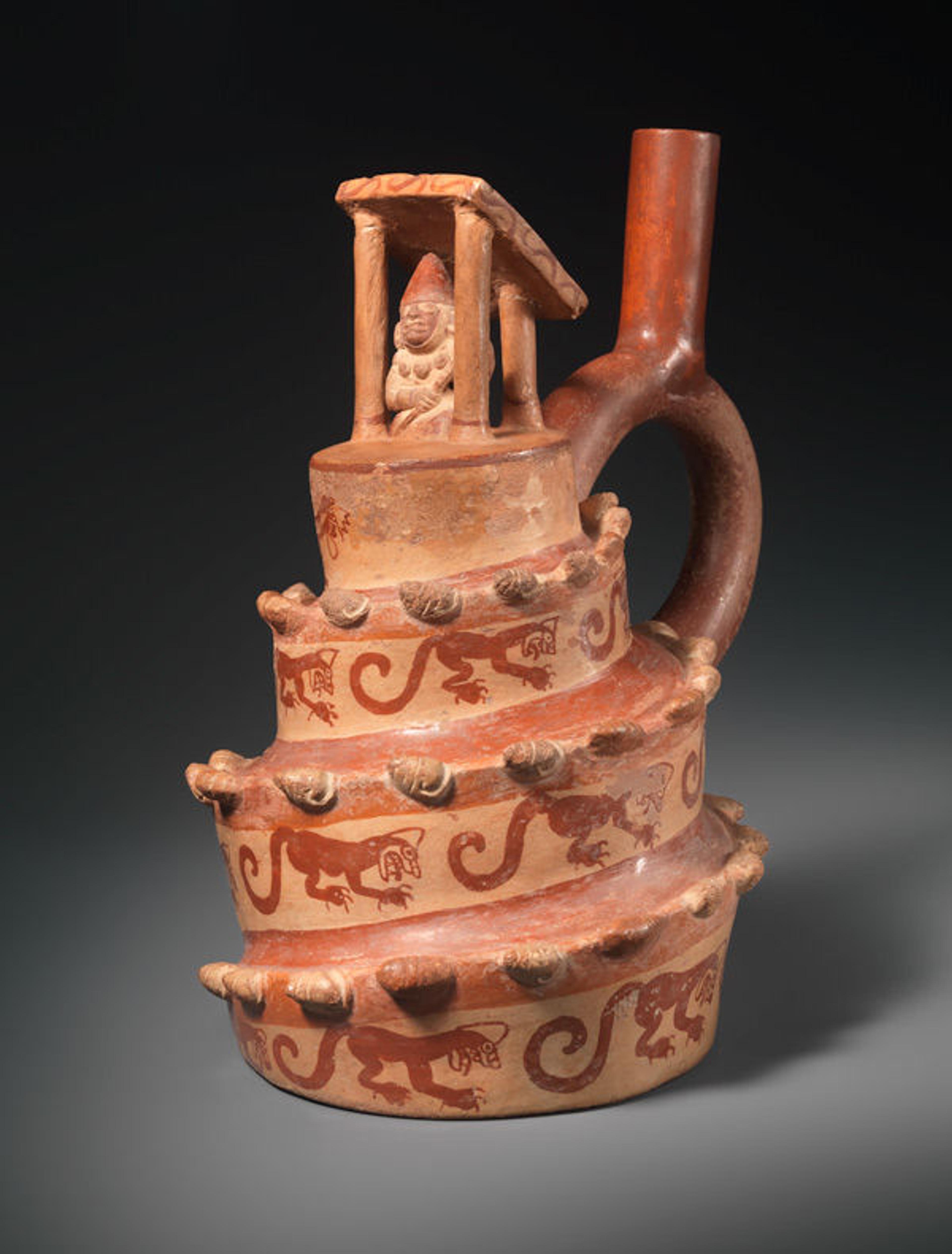 This vessel is modeled in the shape of a spiral platform surmounted by an open-sided structure with a figure inside. Architectural vessel, A.D. 400–600. Peru. Moche. Ceramic; H. 8 7/16 x W. 5 1/2 in. (21.51 x 13.97 cm). The Metropolitan Museum of Art, New York, Gift of Nathan Cummings, 1963 (63.226.13)