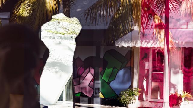 Collage image, of two store fronts on the right side of the image, on the right there is a silhouette shaped crop, along with palm trees overshadowing the back.