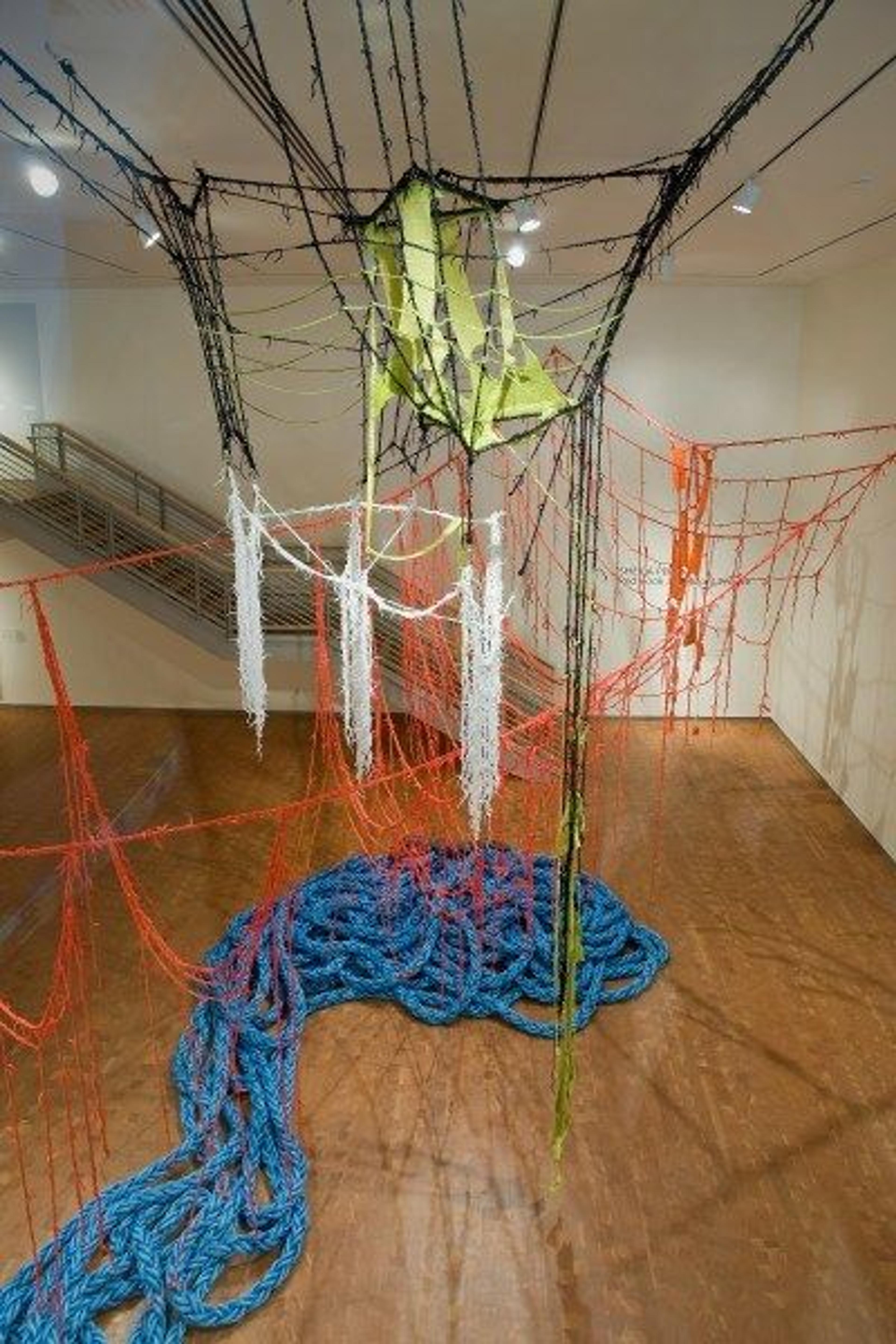 A large colorful installation by artist Sheila Pepe made of shoelaces, cotton yarn and nautical towline