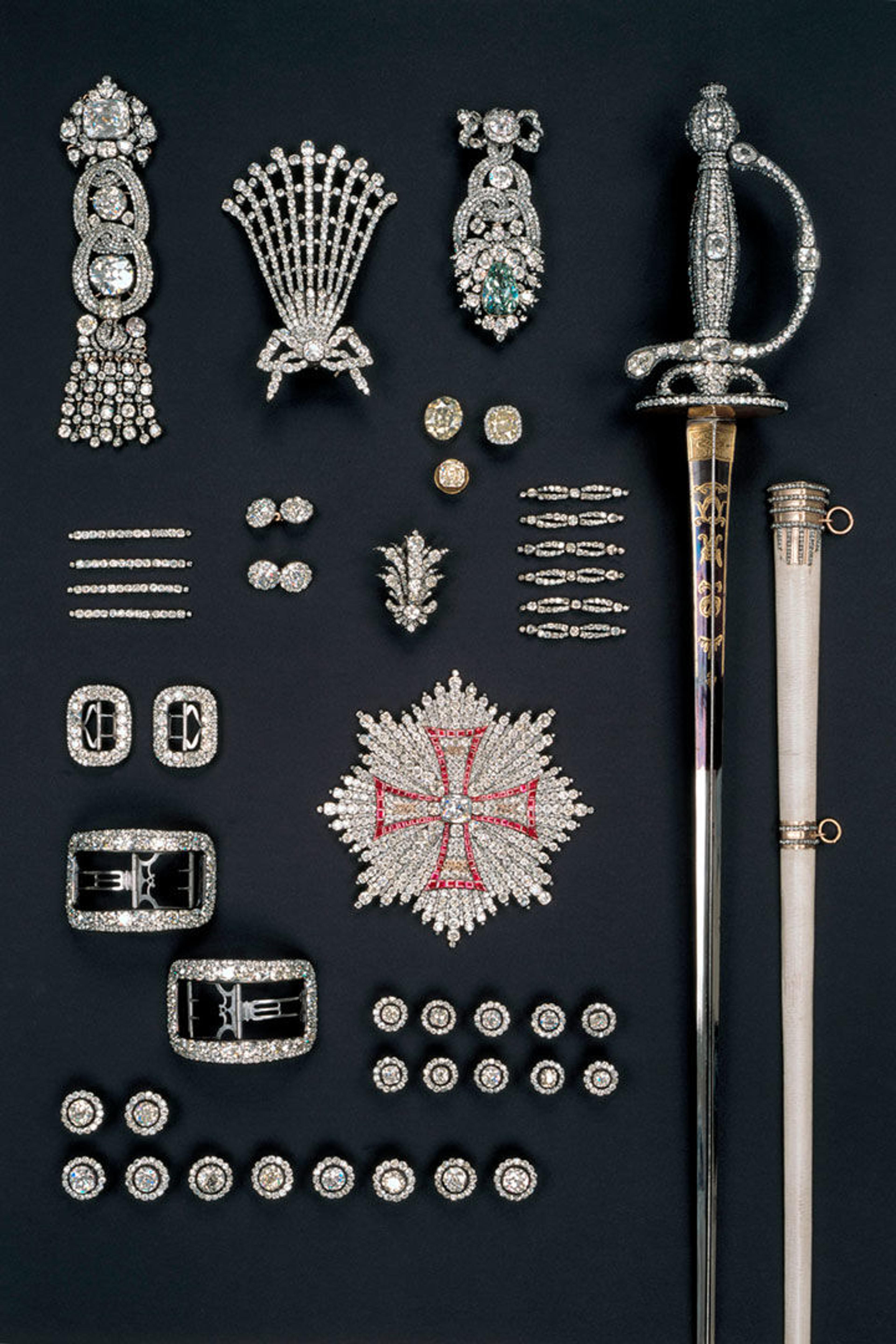 A photograph of various riches laid out on atable, including a sword, gemmed pendants, and the Dresden Green diamond