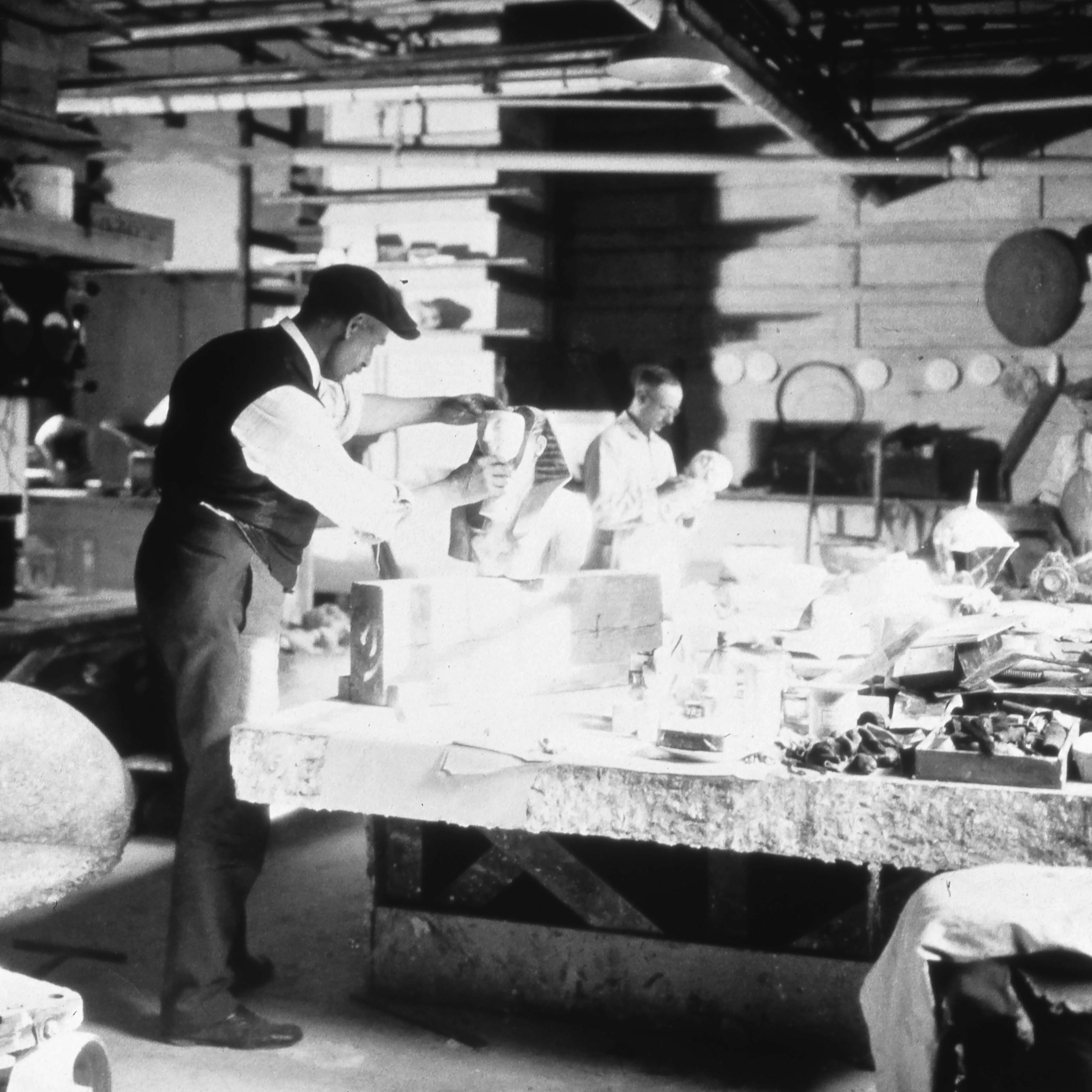 A 1922 photograph (detail) shows a repairer fitting a plaster face to a figure of King Thutmose III.