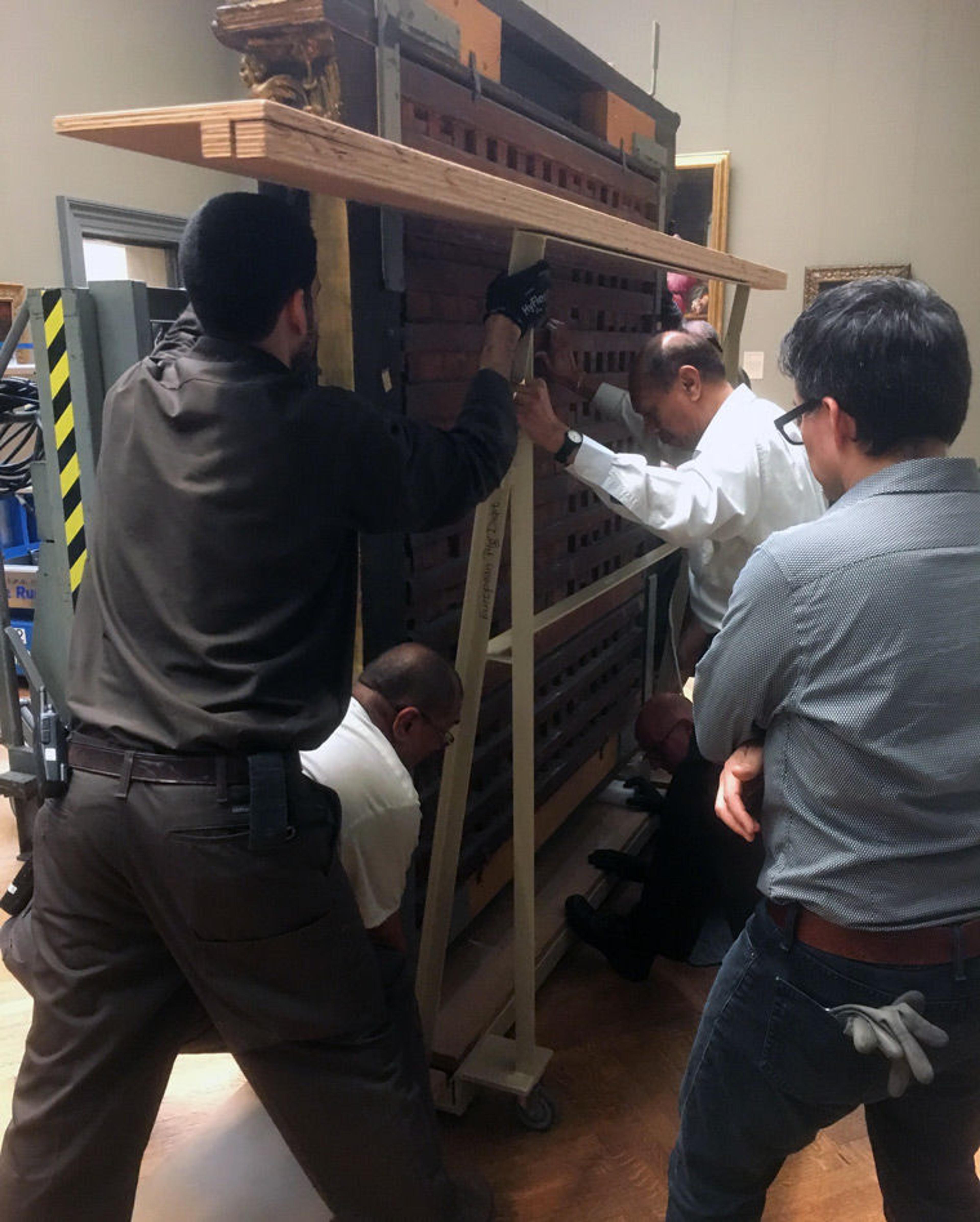 Museum staff move an altarpiece by Raphael in an art gallery