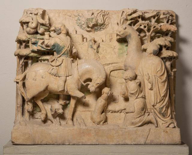 Block relief of a figure kneeling before a horse.