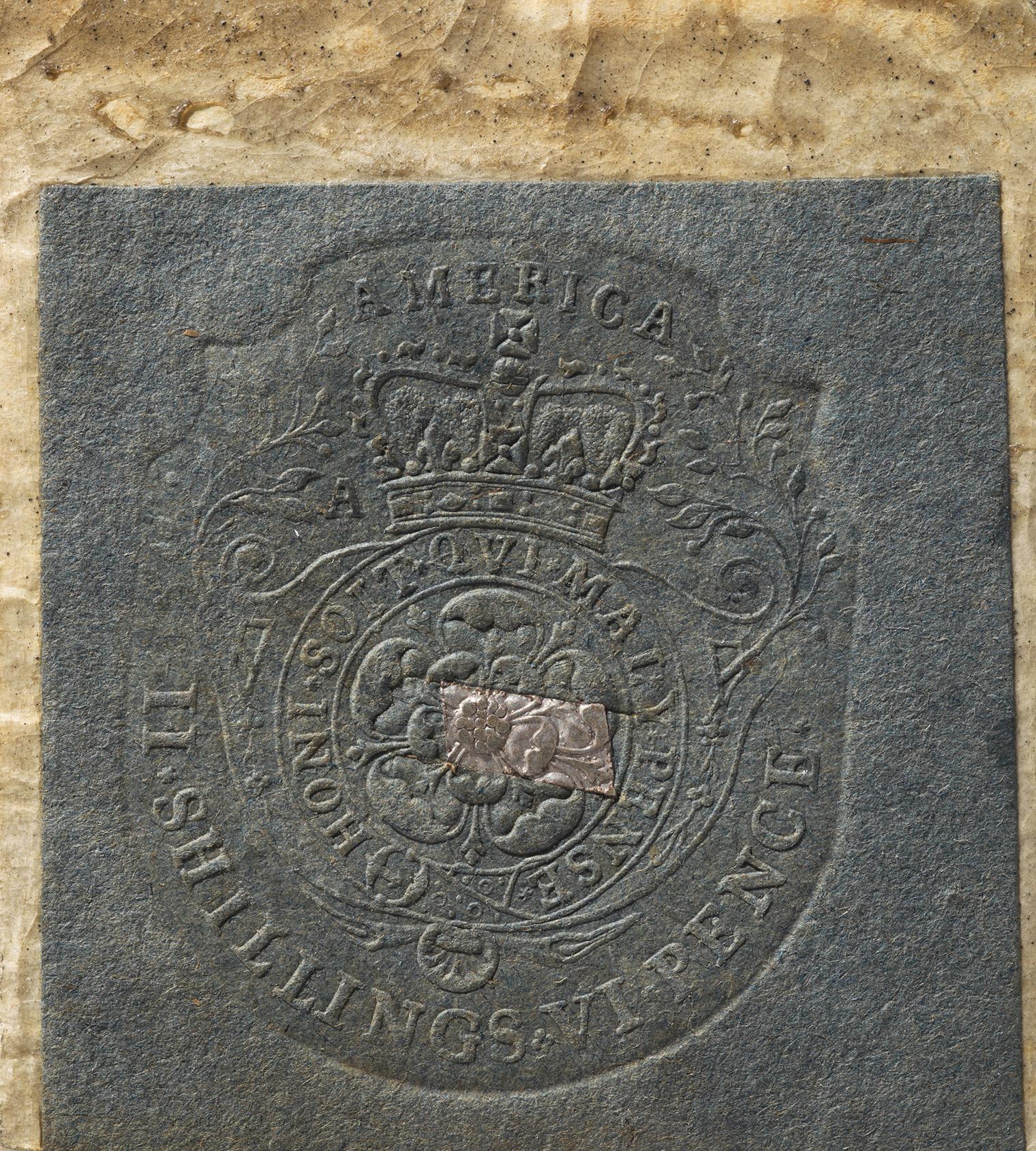 Embossed stamp on blue paper with a crown and floral design, labeled "AMERICA." Text around reads "SHILLINGS." A rectangular cutout is visible.