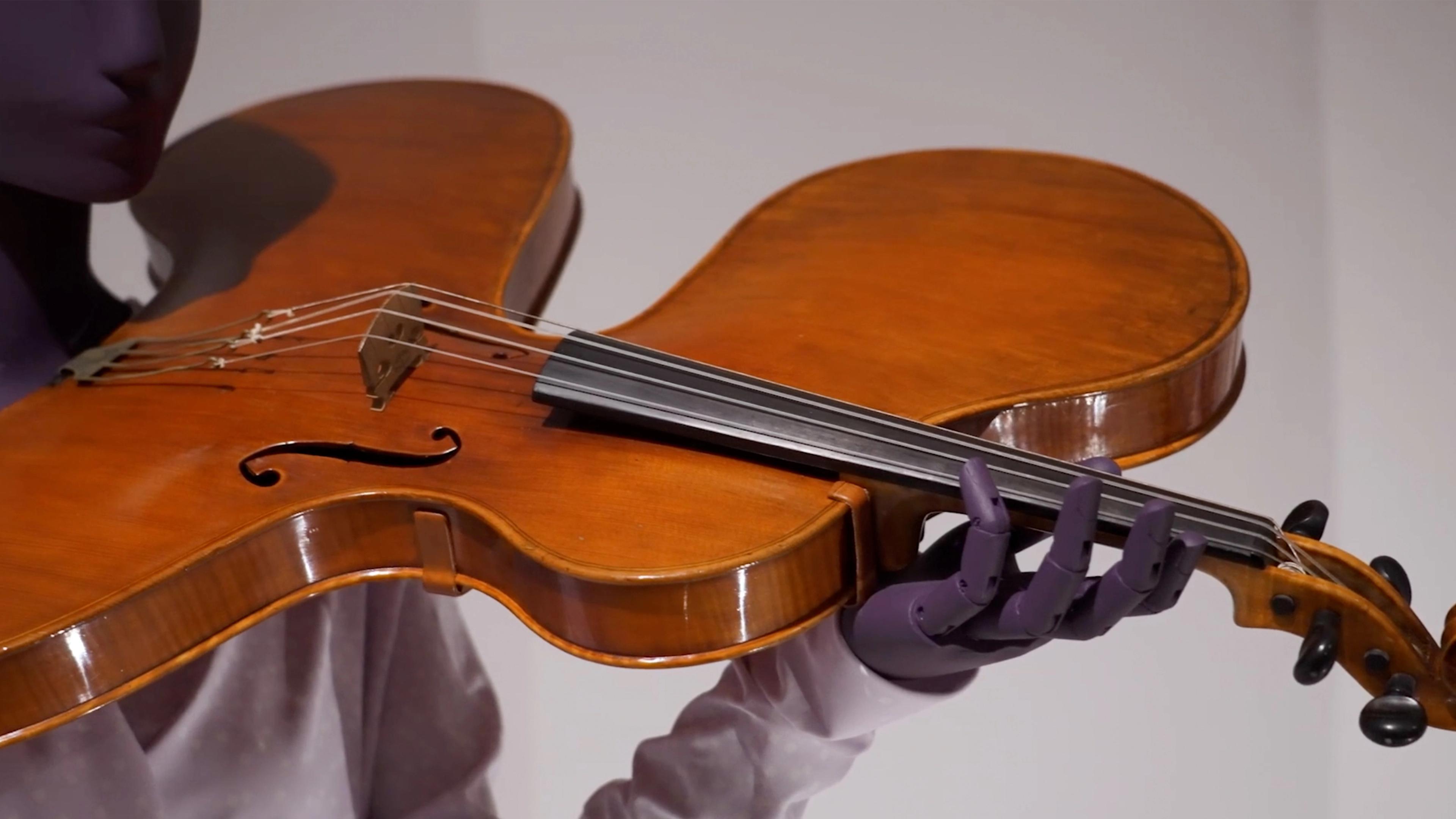 Purple mannequin hand holding a body shaped guitar.