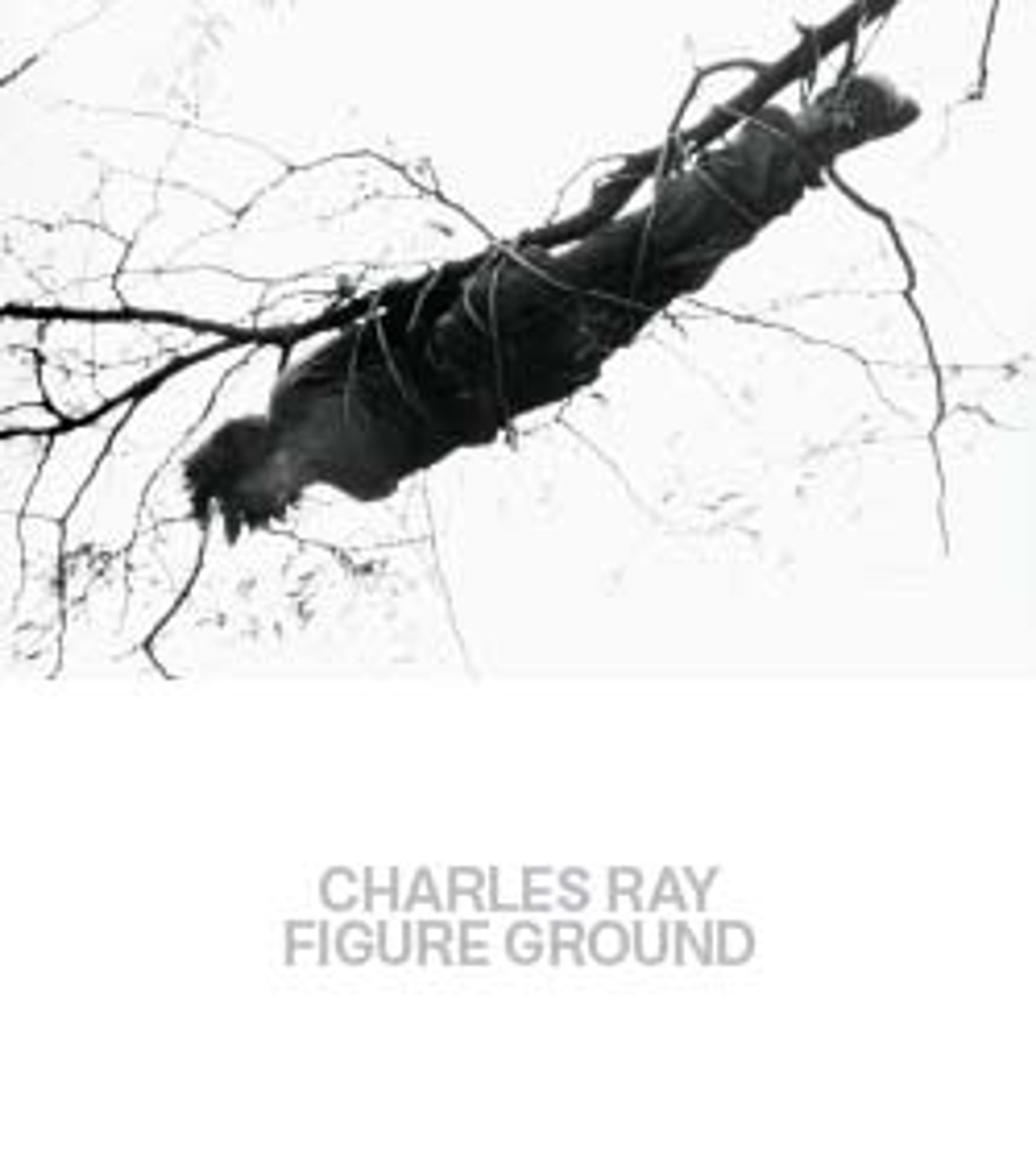the cover of the book "Charles Ray: Figure Ground," with a photograph of a man facing downwards bound to the underside of a tree branch