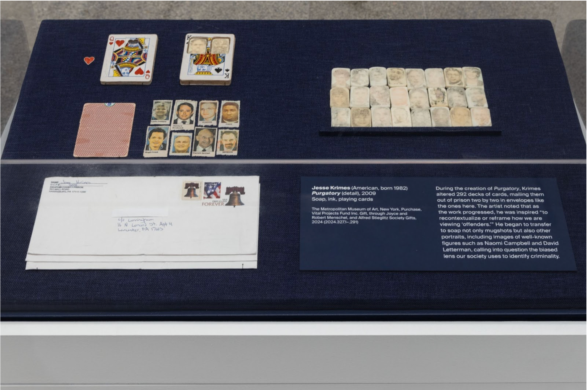 Glass display of various items, from soap figures, playing cards, and assorted mail.