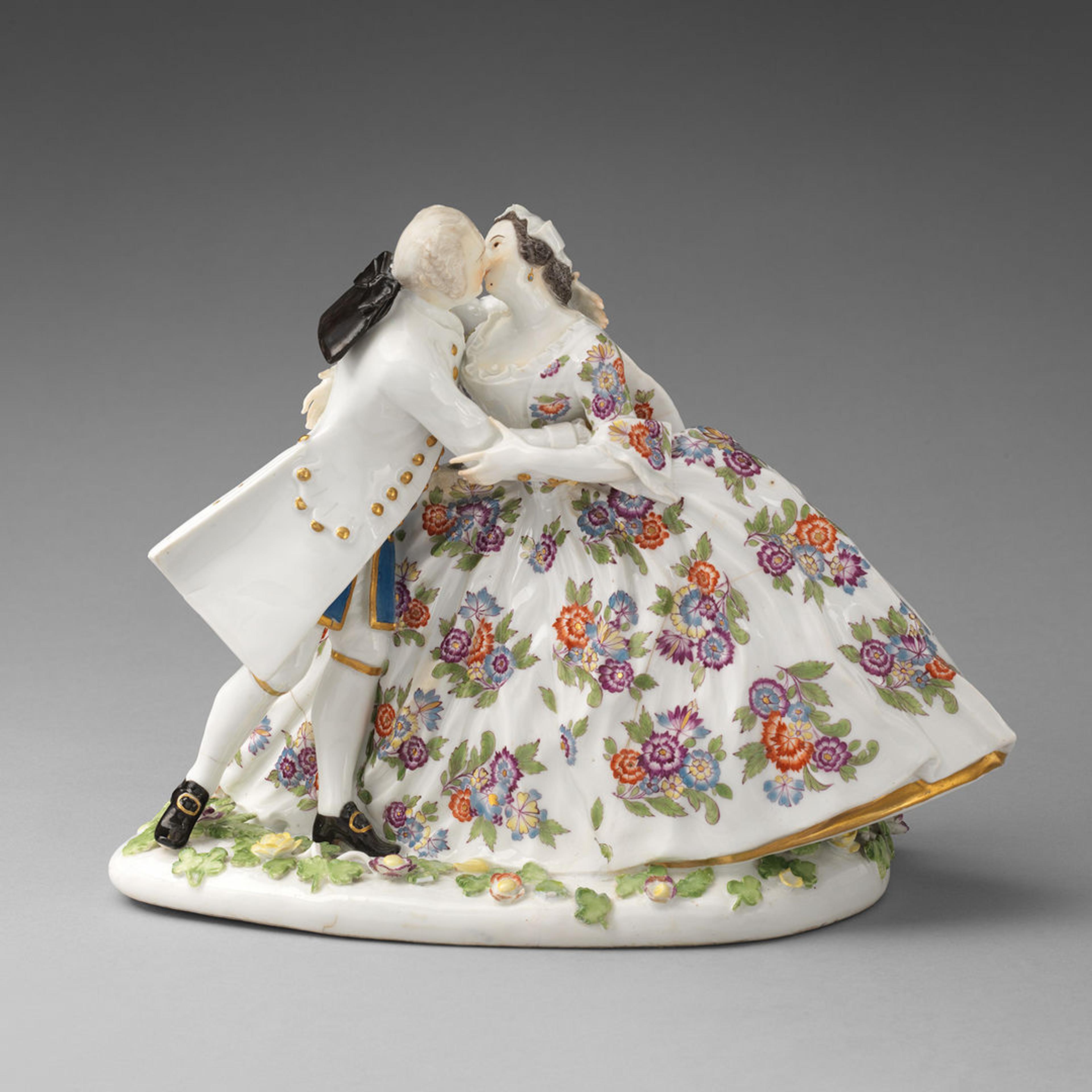 French porcelain figures of a man and women kissing done in Rococo style.