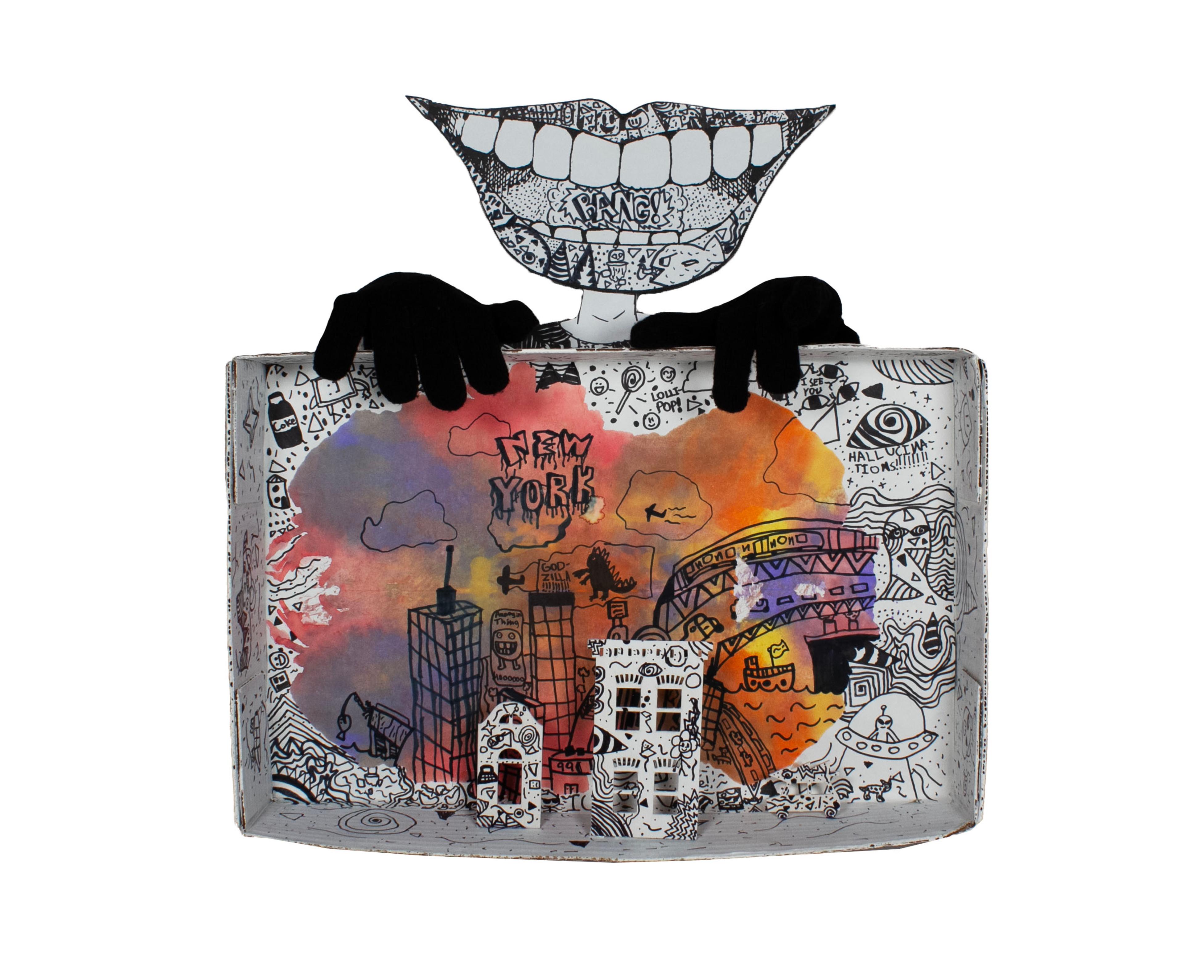Sharpie illustration drawn on the propped-up interior of an opened rectangular white cardboard box, suggesting a window or TV screen. A pair of black, gloved hands rest upon the top of the box, fingers dangling over the edge. Between and above the hands is an extremely large, exaggerated pair of black-and-white, open smiling lips showing teeth, cut out of cardboard and mounted over a small, narrow neck. Inside the open mouth, between the teeth, the word BANG is written. Inside the box below, a city skyline is drawn within a large, orange-hued vignette. The words NEW YORK are written in the sky. Within the box, on the bottom surface of the inner lid, a pair of white cutout buildings sit propped in front of the orange vignette. Intricate black line work decorates the entire box, from the mouth above to the cityscape below. Adornments along the interior of the box include a soda bottle, a lollipop, and a flyer saucer piloted by an alien.