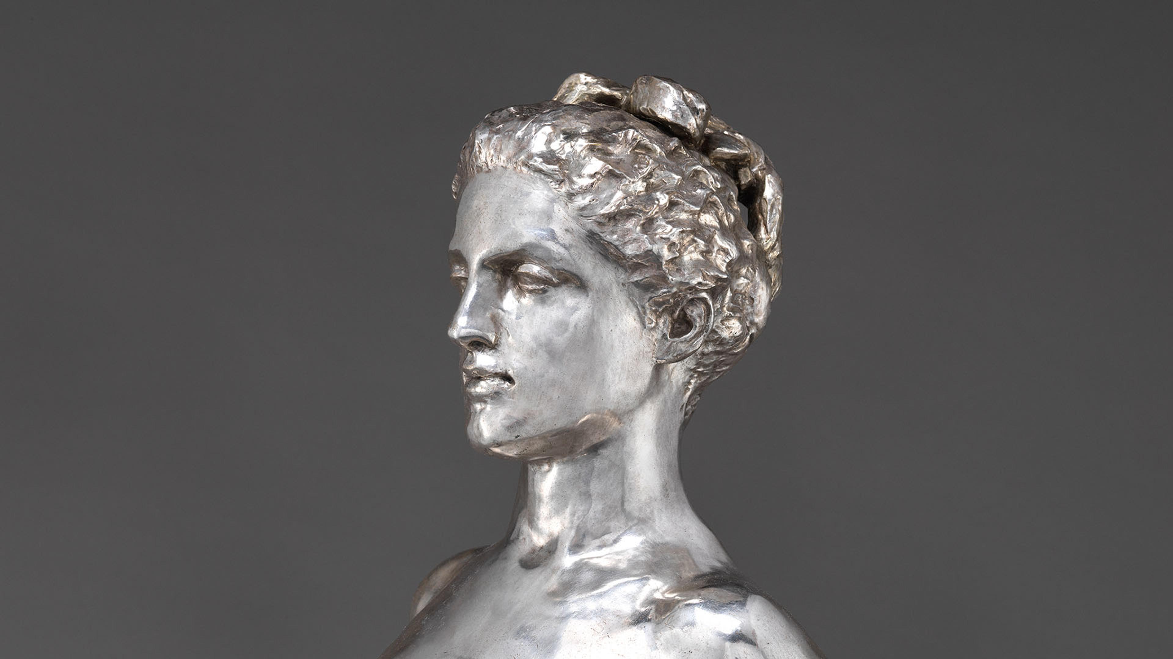 A sculpture of a woman carved out of silver