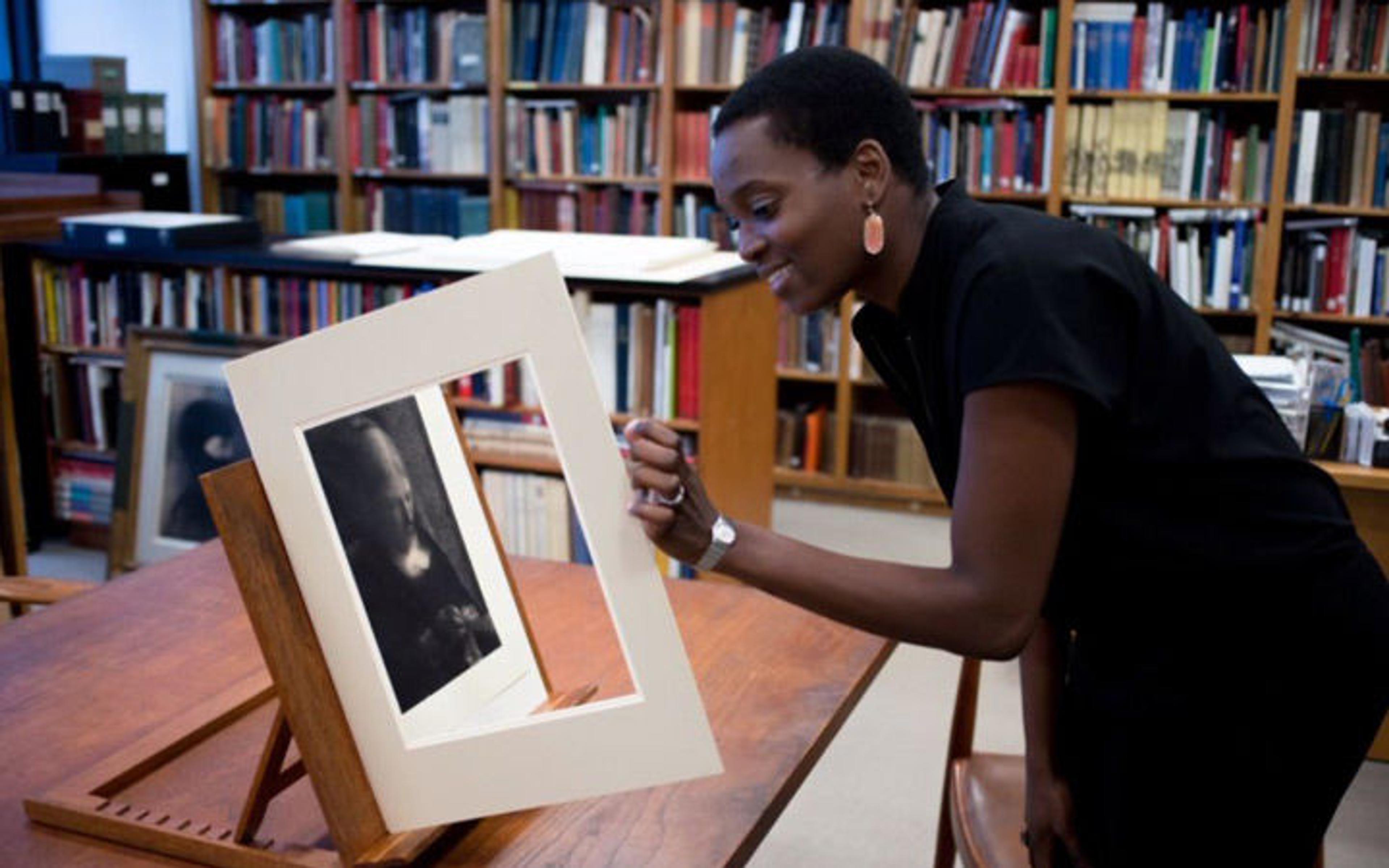 Njideka Akunyili Crosby smiles as she looks at a drawing by Georges Seurat
