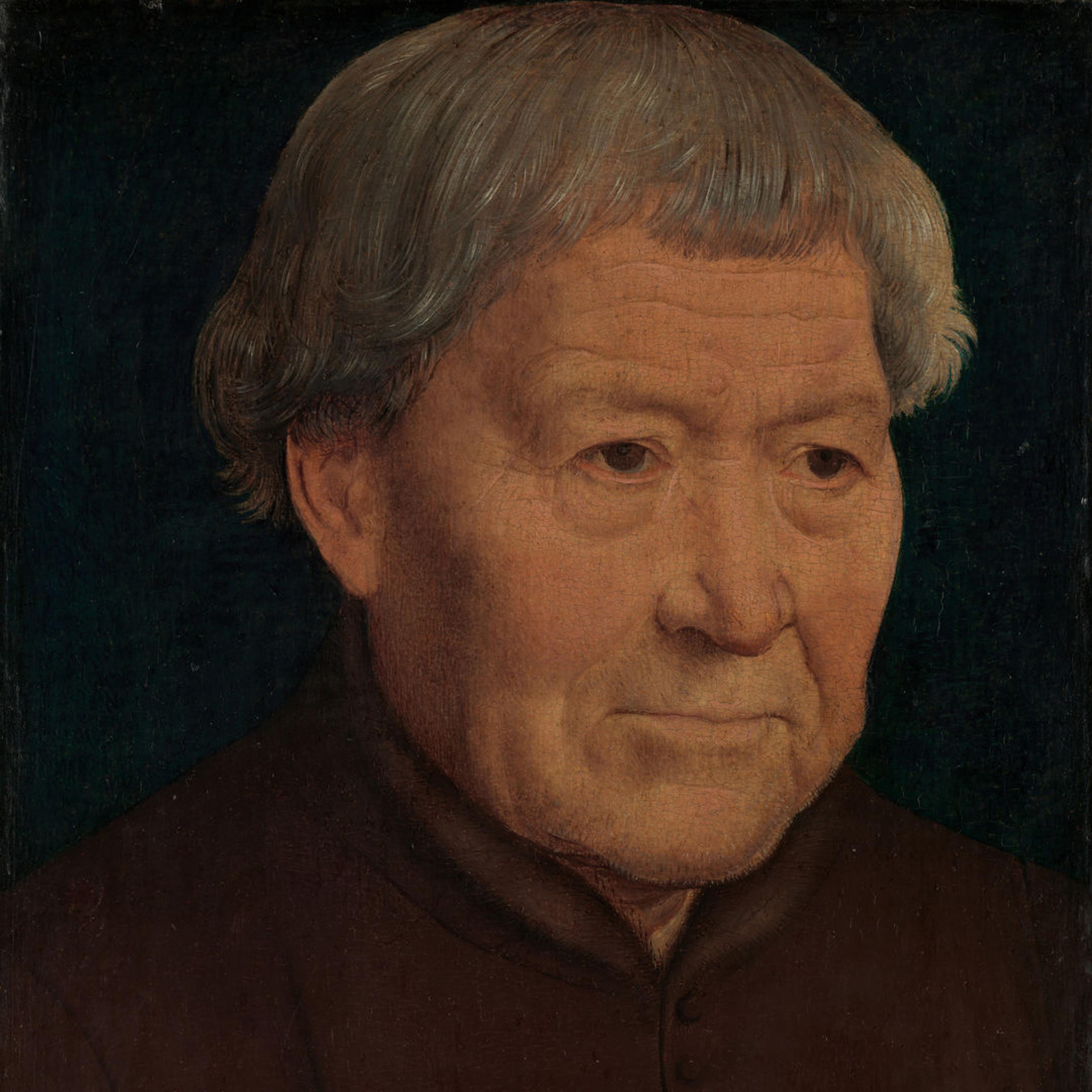 Portrait of an old man in a simple brown tunic with fur trim. His hands are placed over each other in the bottom right corner of the frame.