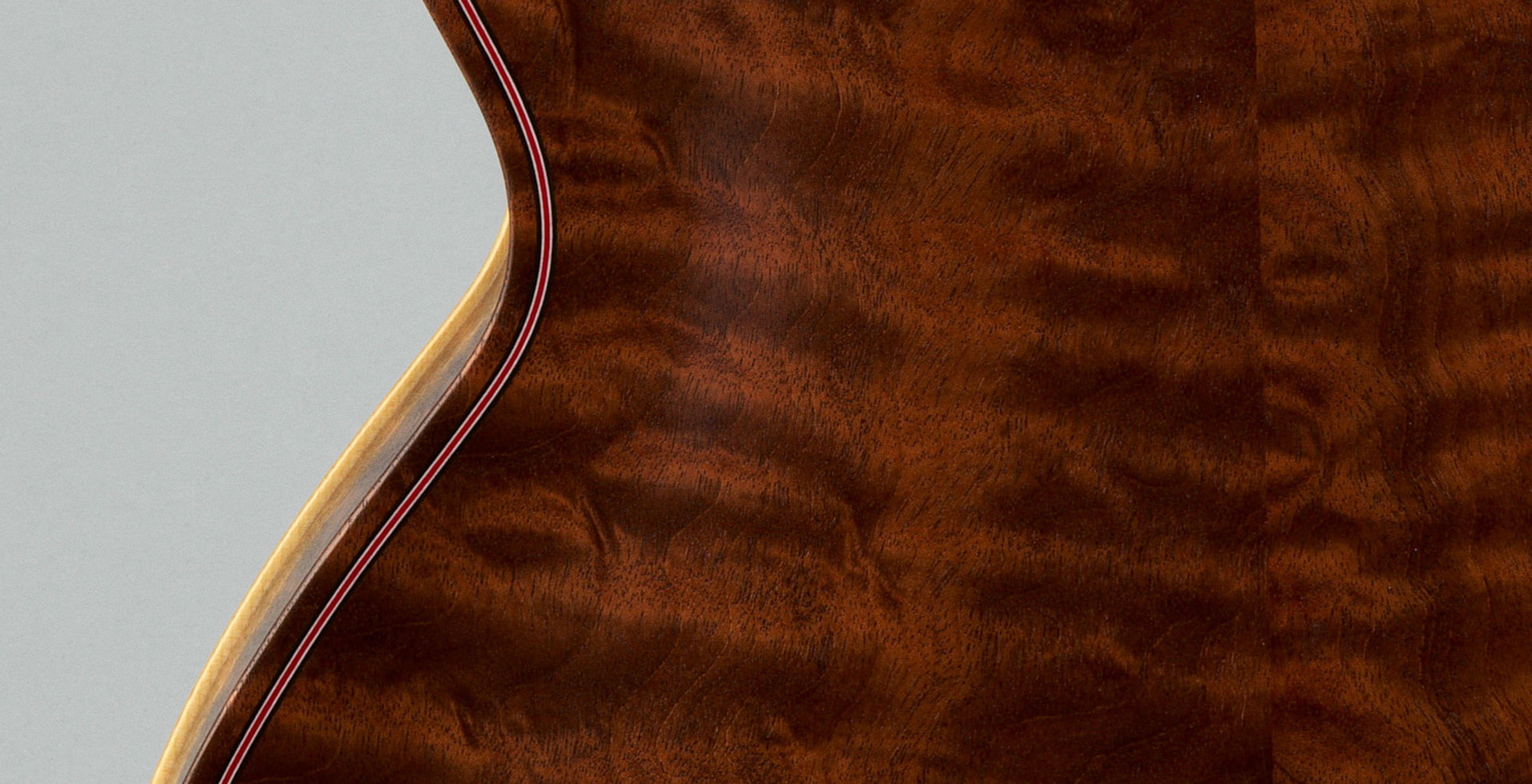 Detail of a guitar backside. The shiny mahogany wood has varying shades of brown, creating an almost marbled effect.