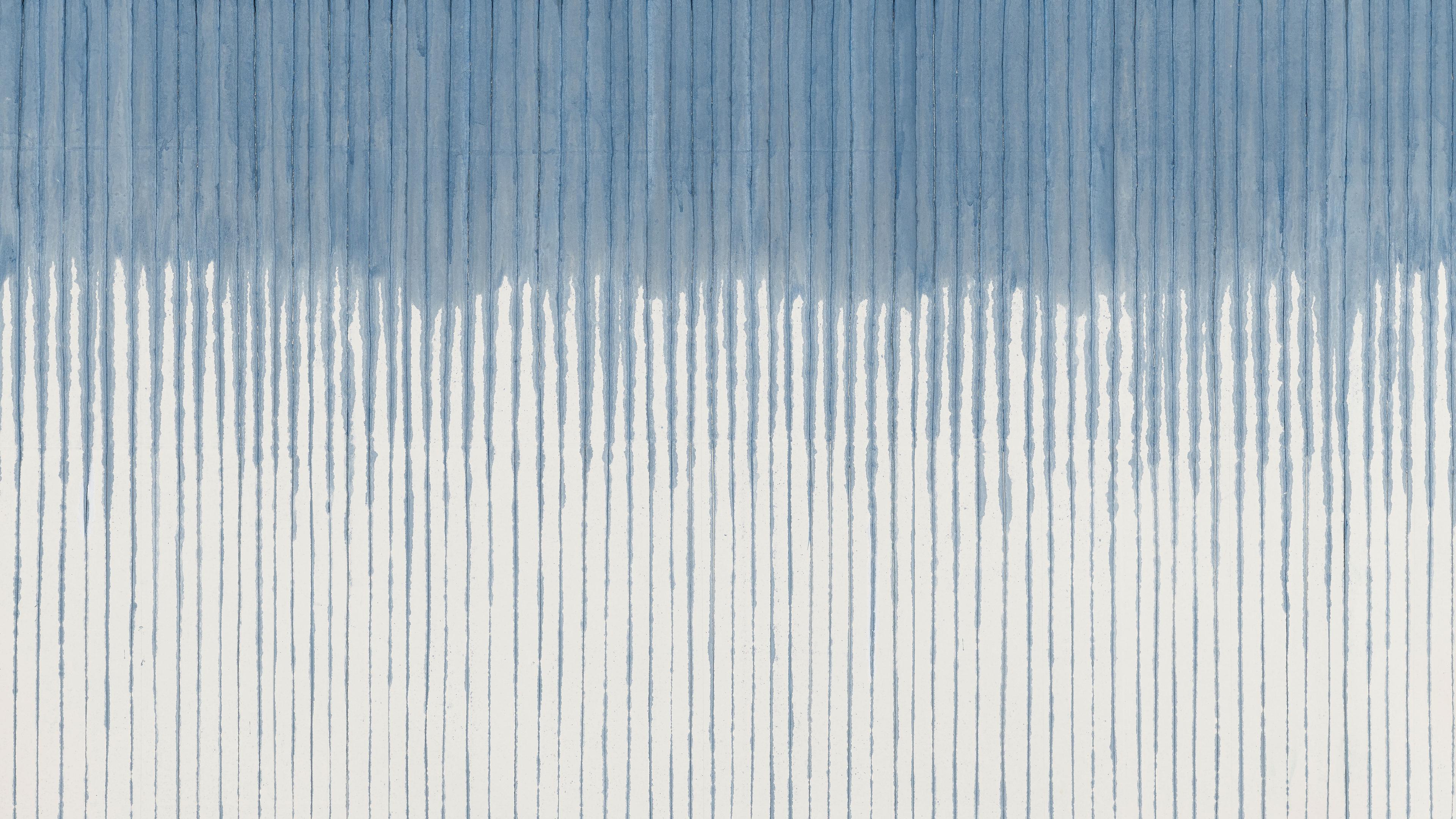 A large white canvas with dripping, vertical indigo lines spaced closely together. The indigo color is concentrated at the top of the canvas then trails off as it makes its way down.