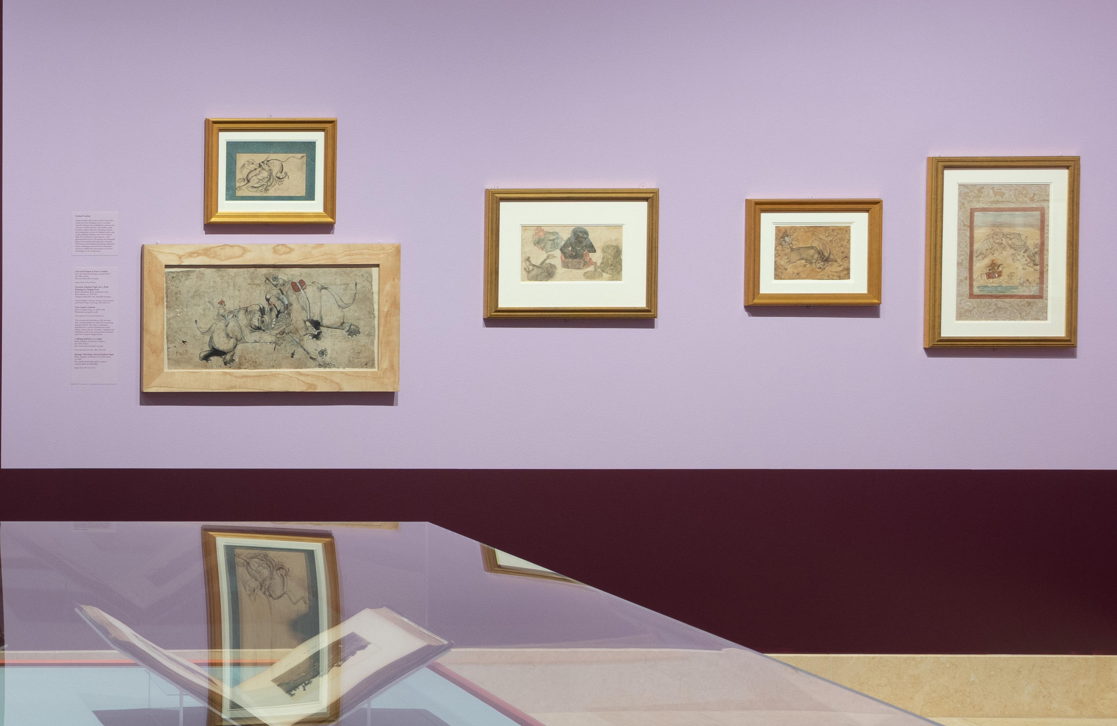 An art gallery room with purple walls displays framed historical paintings. The pieces are varied in size, and a glass display case is partially visible.