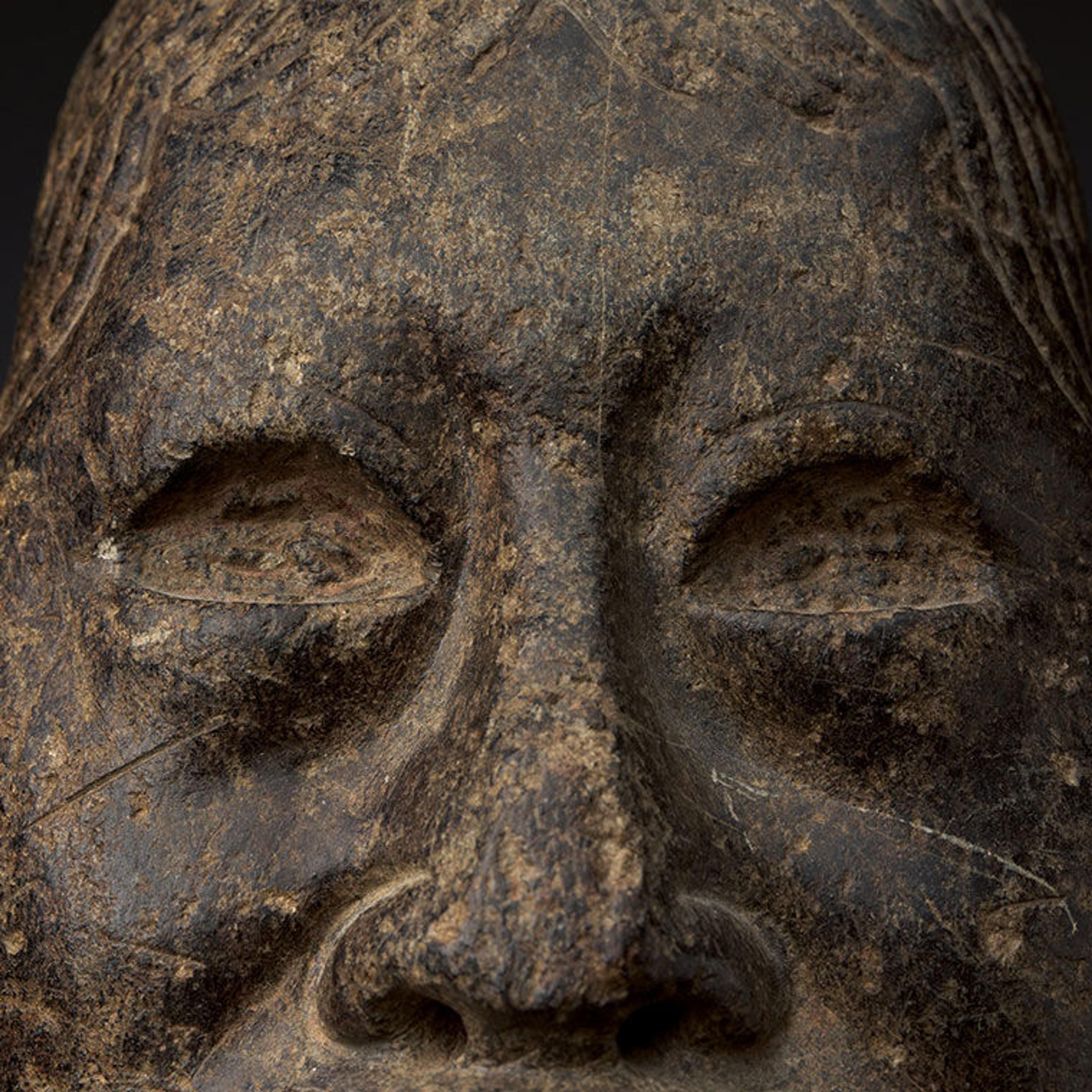 Close up view of the face of an Olmec kneeling figure