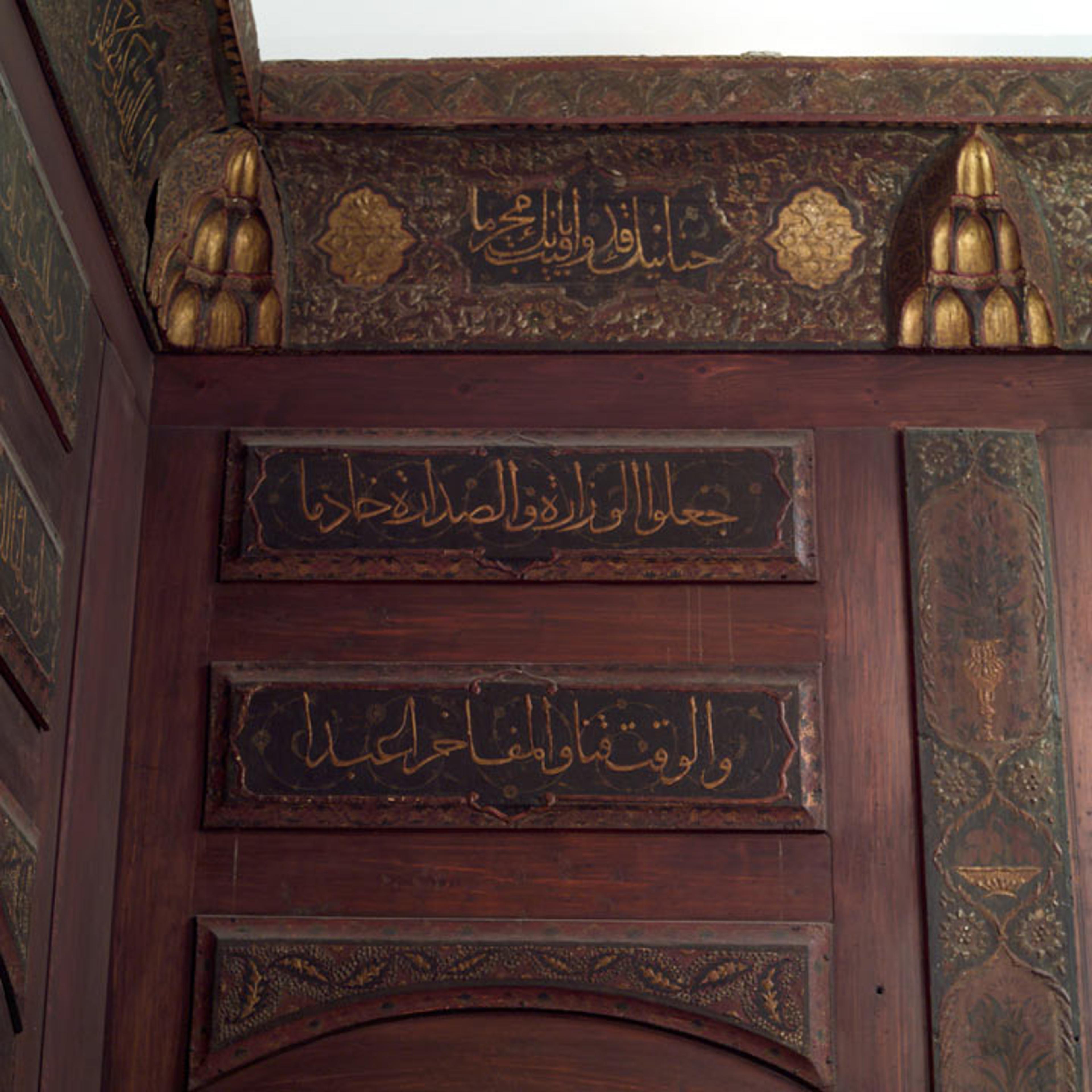 Detail view of calligraphy inlaid on wood paneling