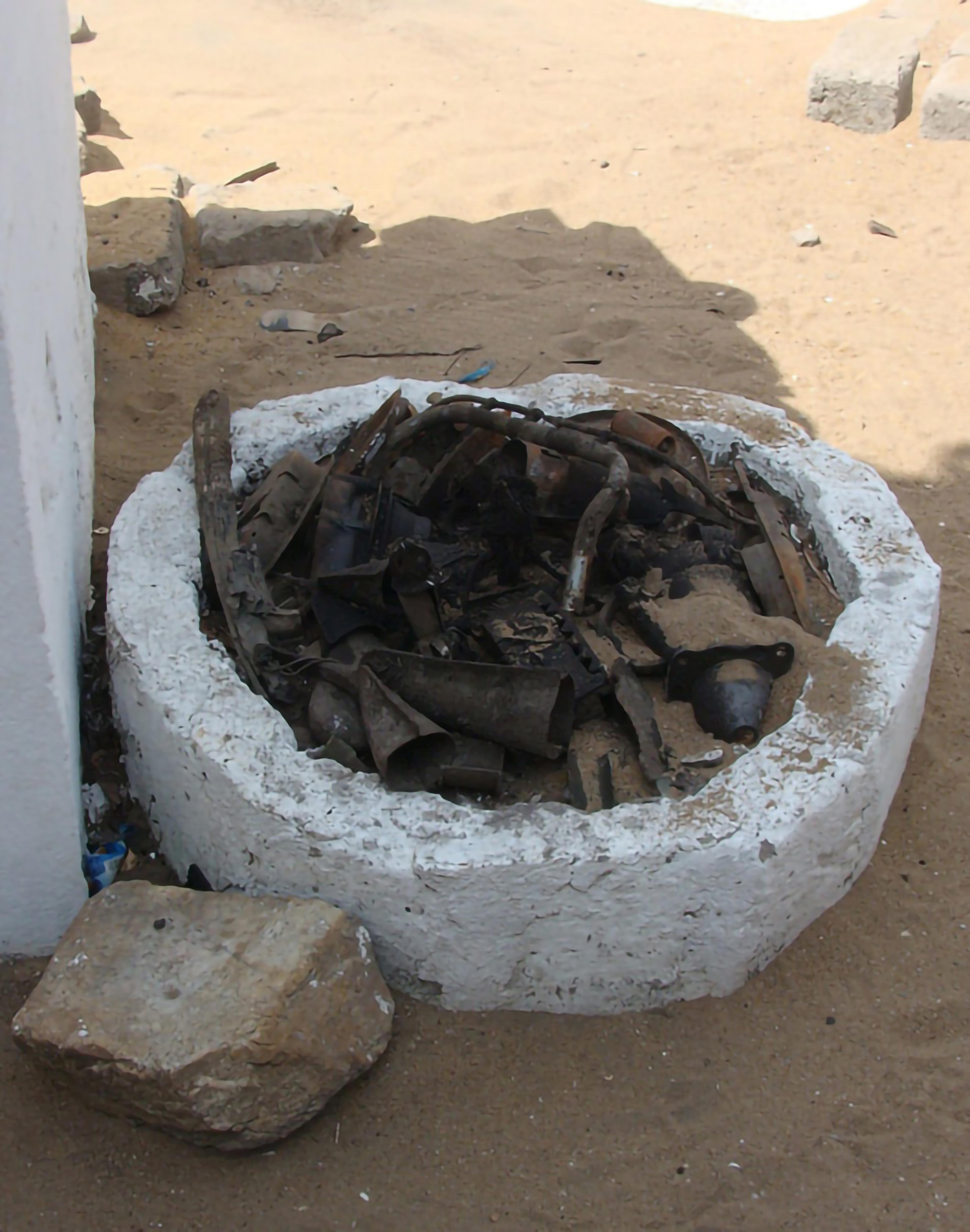 Shrine comprised of a stone/concrete circular pit, with unidentifiable items inside.