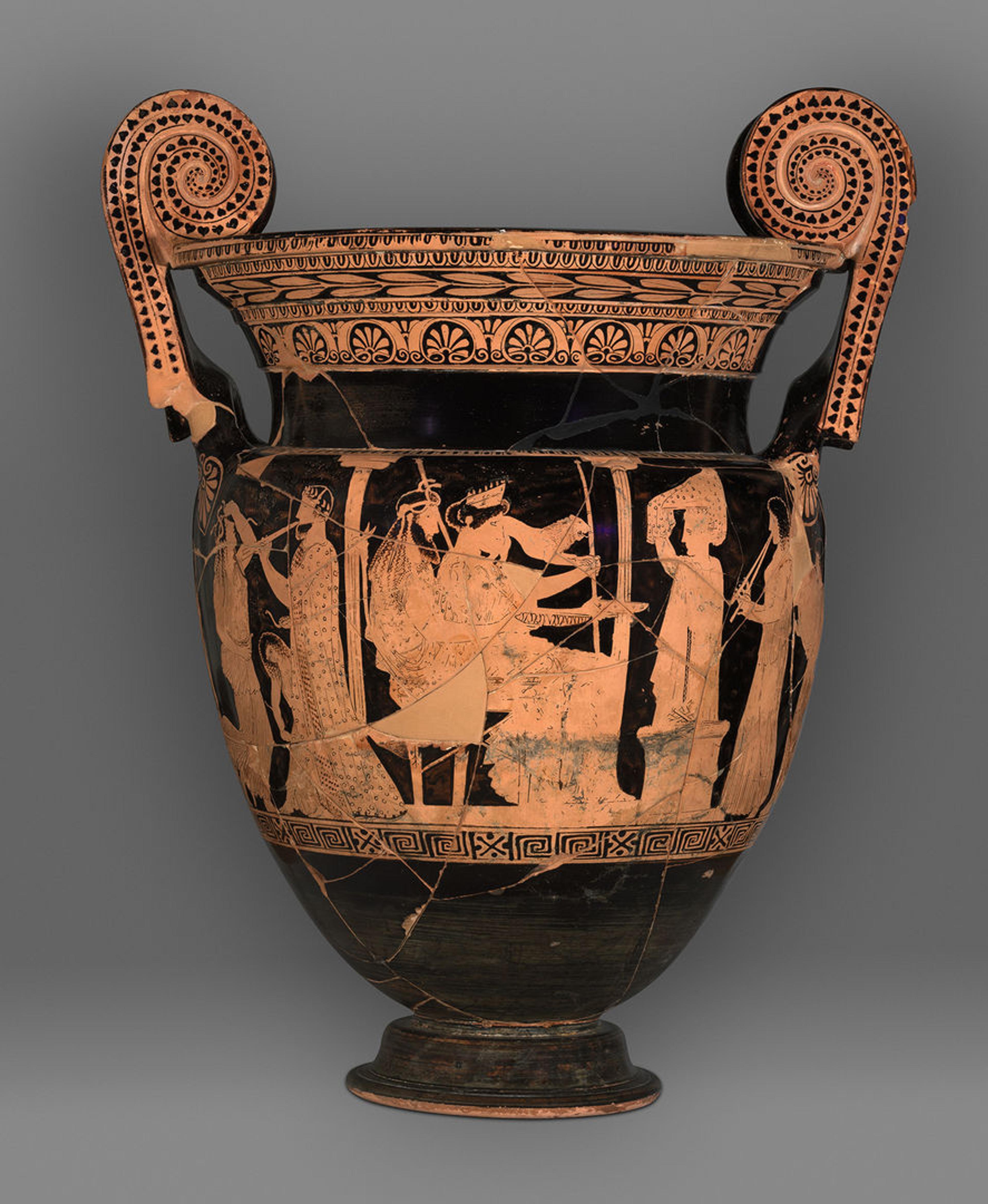 A black volute-krater with copper-colored accents. Geometric patterns accent the lip and handles of the vessel, while the scene on the body shows a divine couple seated between two columns, flanked by a priestess and figures playing instruments.