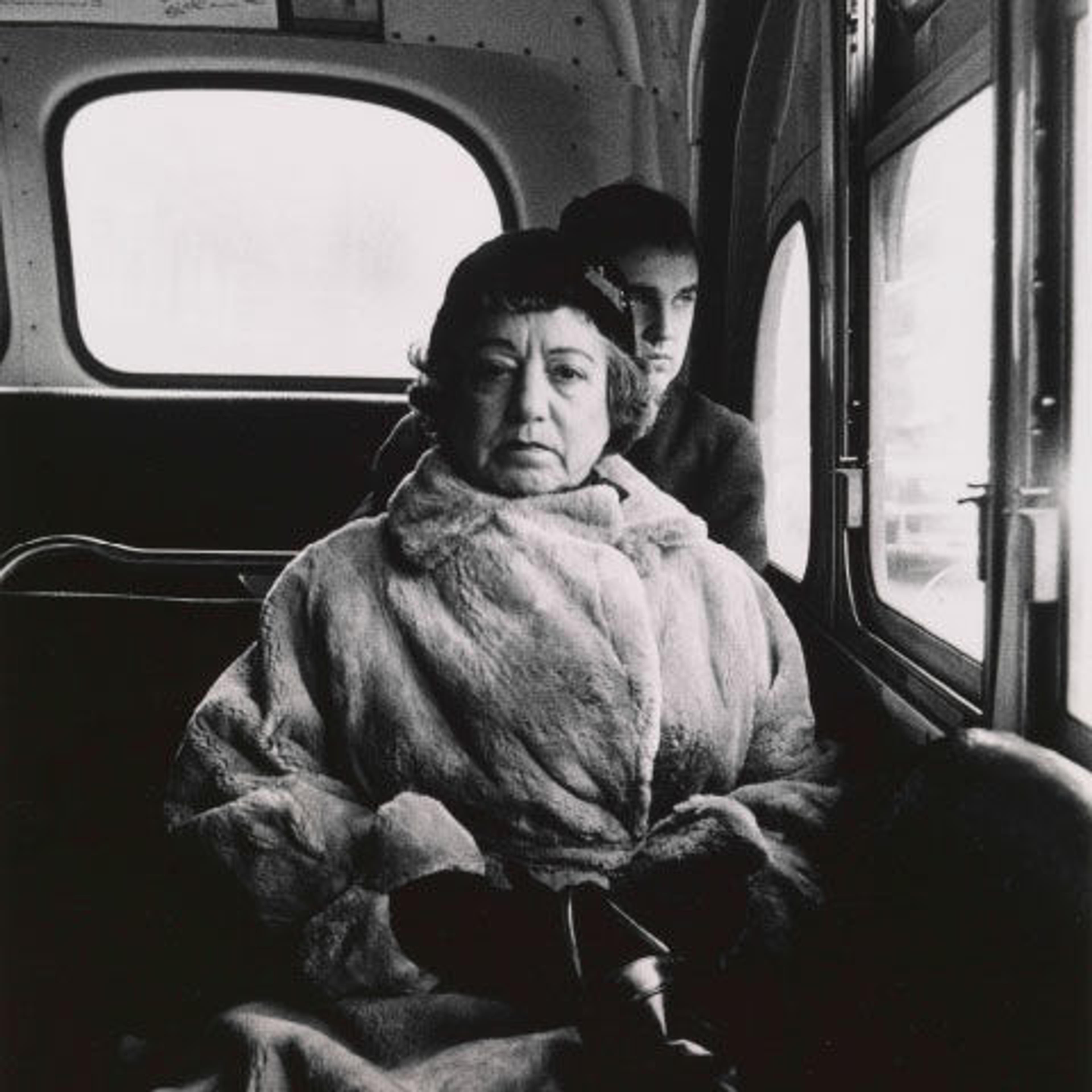 Black-and-white photograph of a woman on a bus