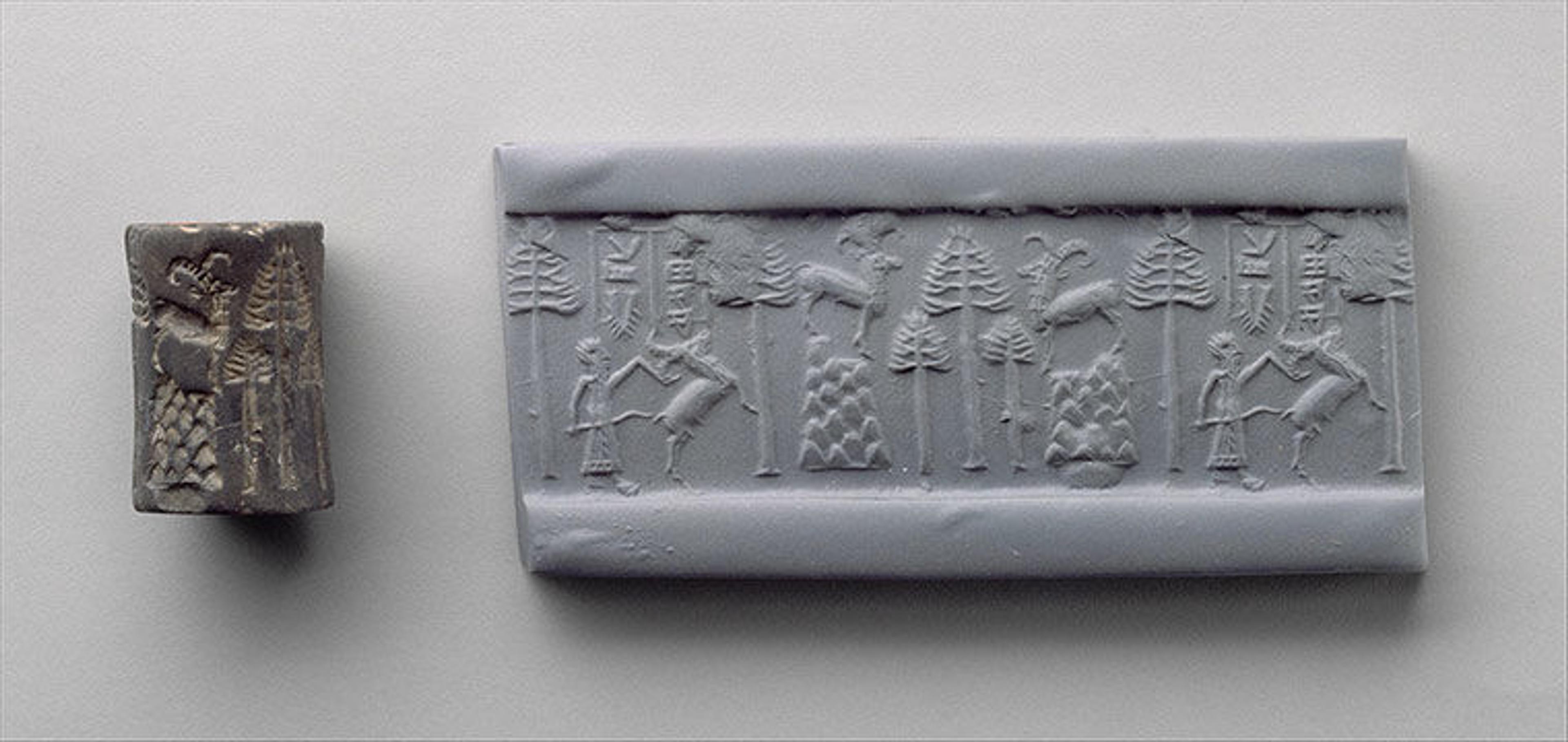 A charcoal-colored cylinder seal next to a rectangular piece of clay on which the seal was rolled. The impression left by the cylinder seal on the clay shows a hunting scene. 