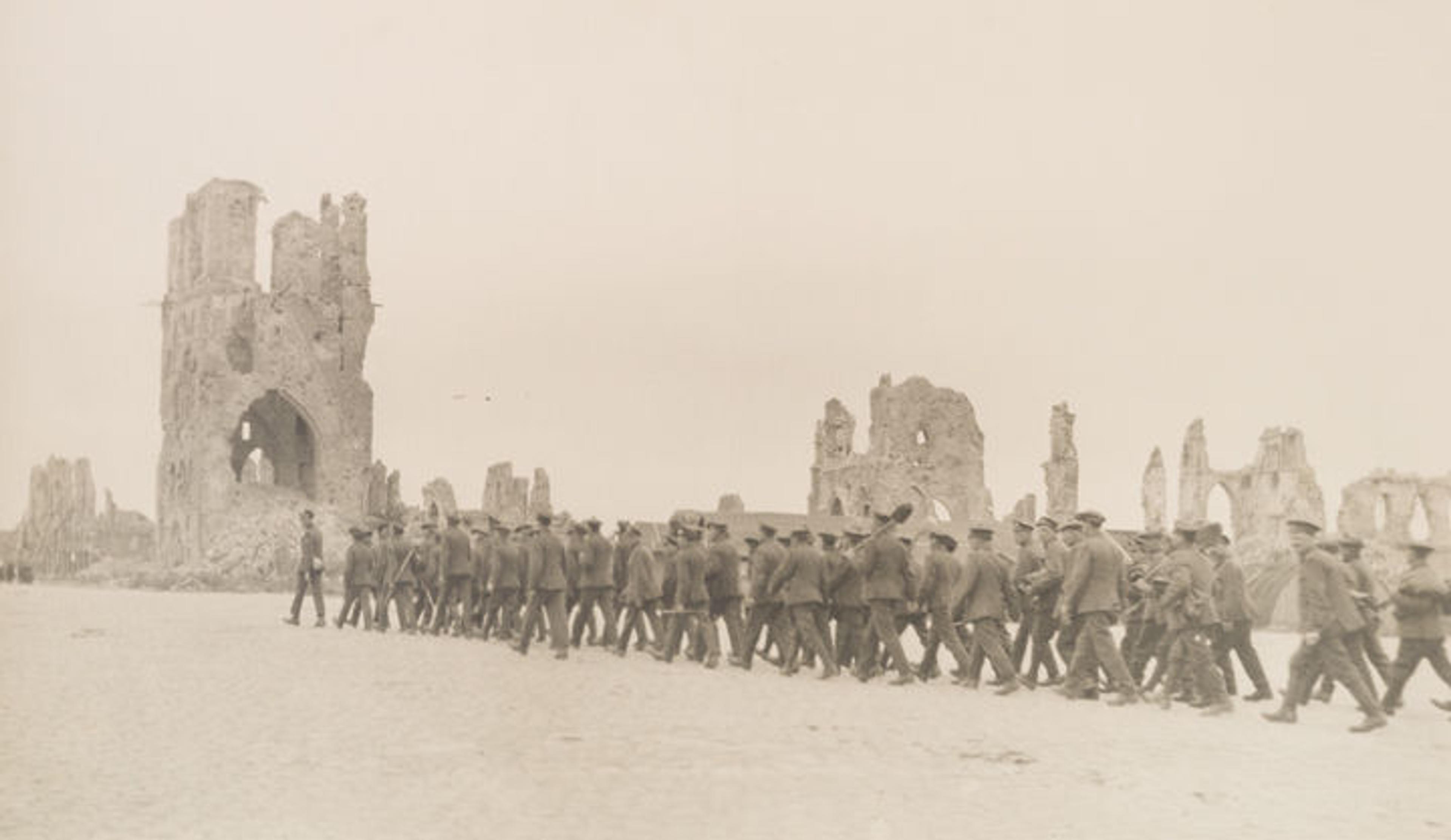 Photo by Margaret Hall showing a group of soldiers marching toward the ruins of a Belgian cathedral