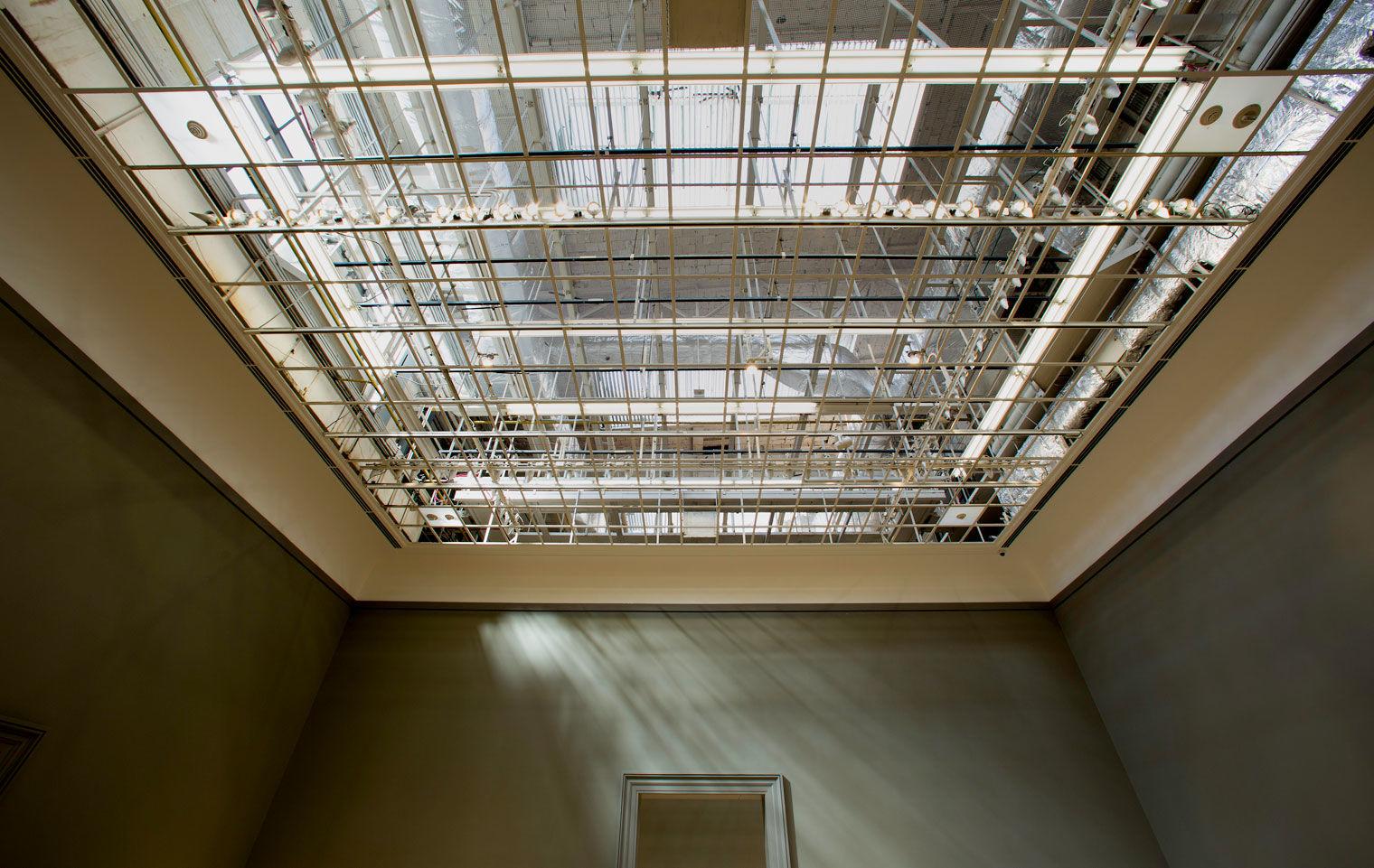 View of an empty gallery in The Met with exposed skylights in the ceiling