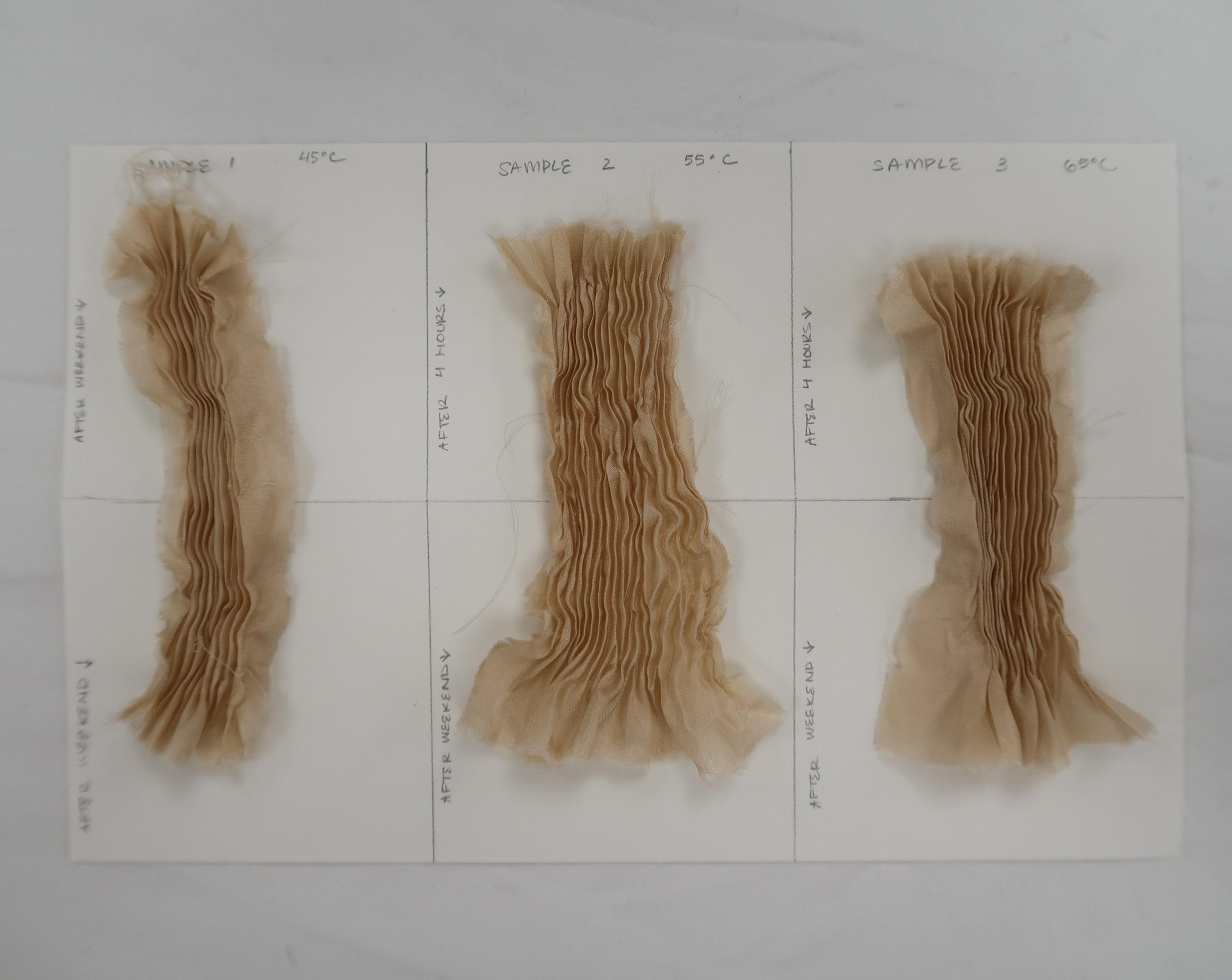 Three pieces of beige pleated fabric on top of a piece of white paper.