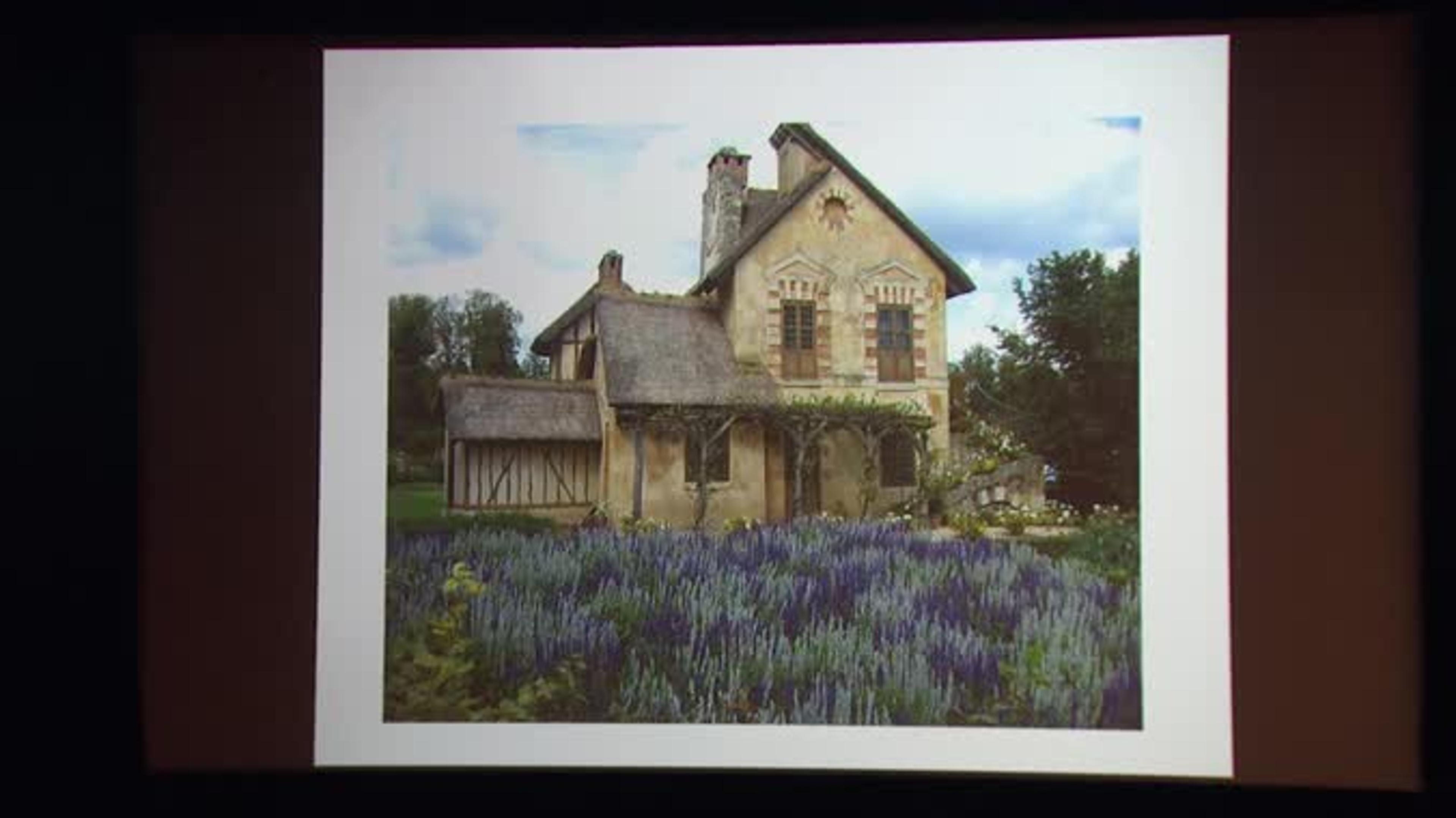 Photograph of an old stone house with lavender growing in the front yard