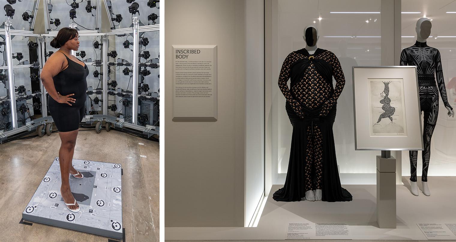 Museum visitor stands beside a scale display, while mannequins model black patterned gowns near a framed fashion illustration in a gallery.