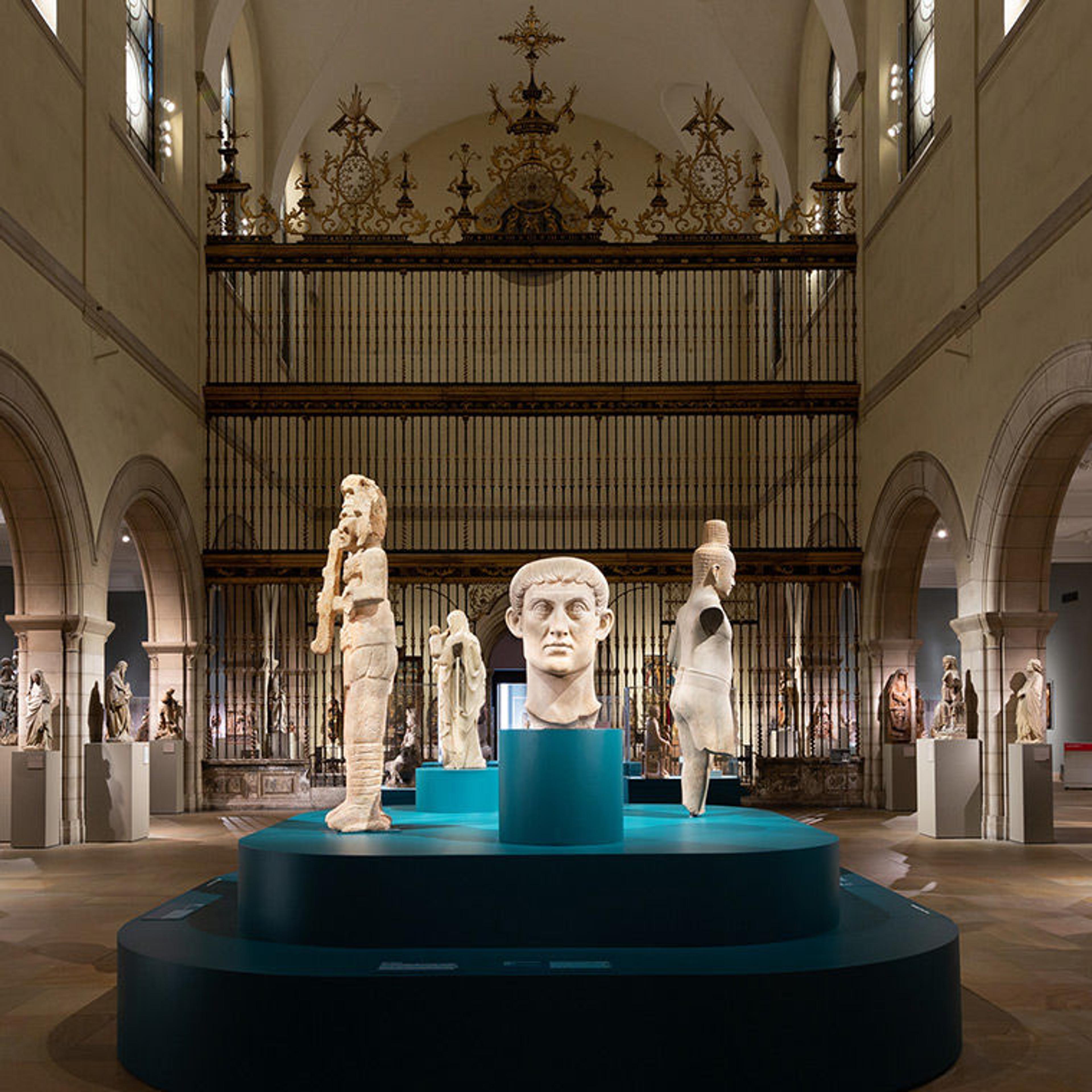 A view of the Medieval Sculpture Hall, with a blue plinth supporting sculptures from many different civilizations