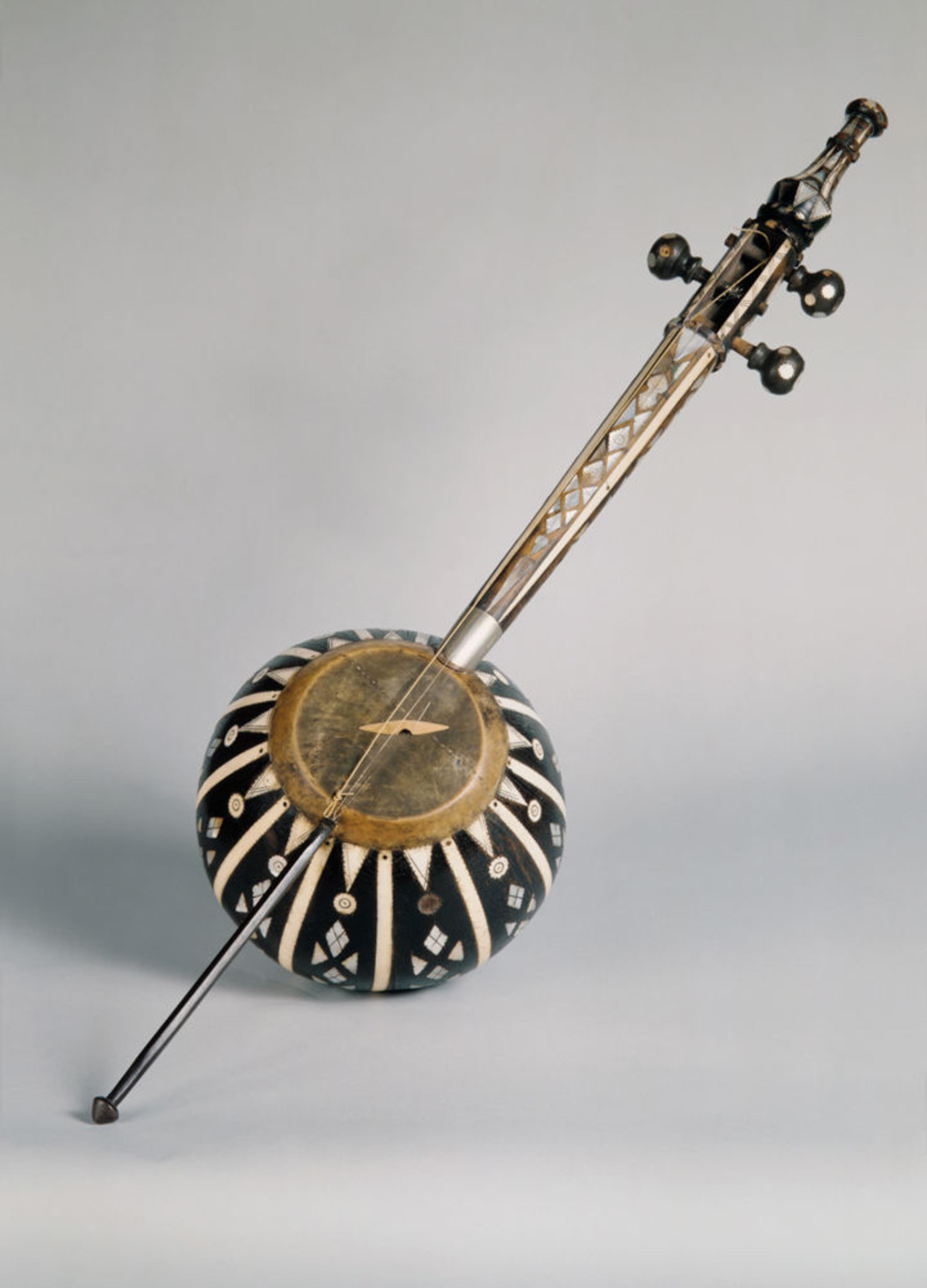 Picture of a kamanche, a bowed string instrument with a round body decorated with black and white triangular patterns.