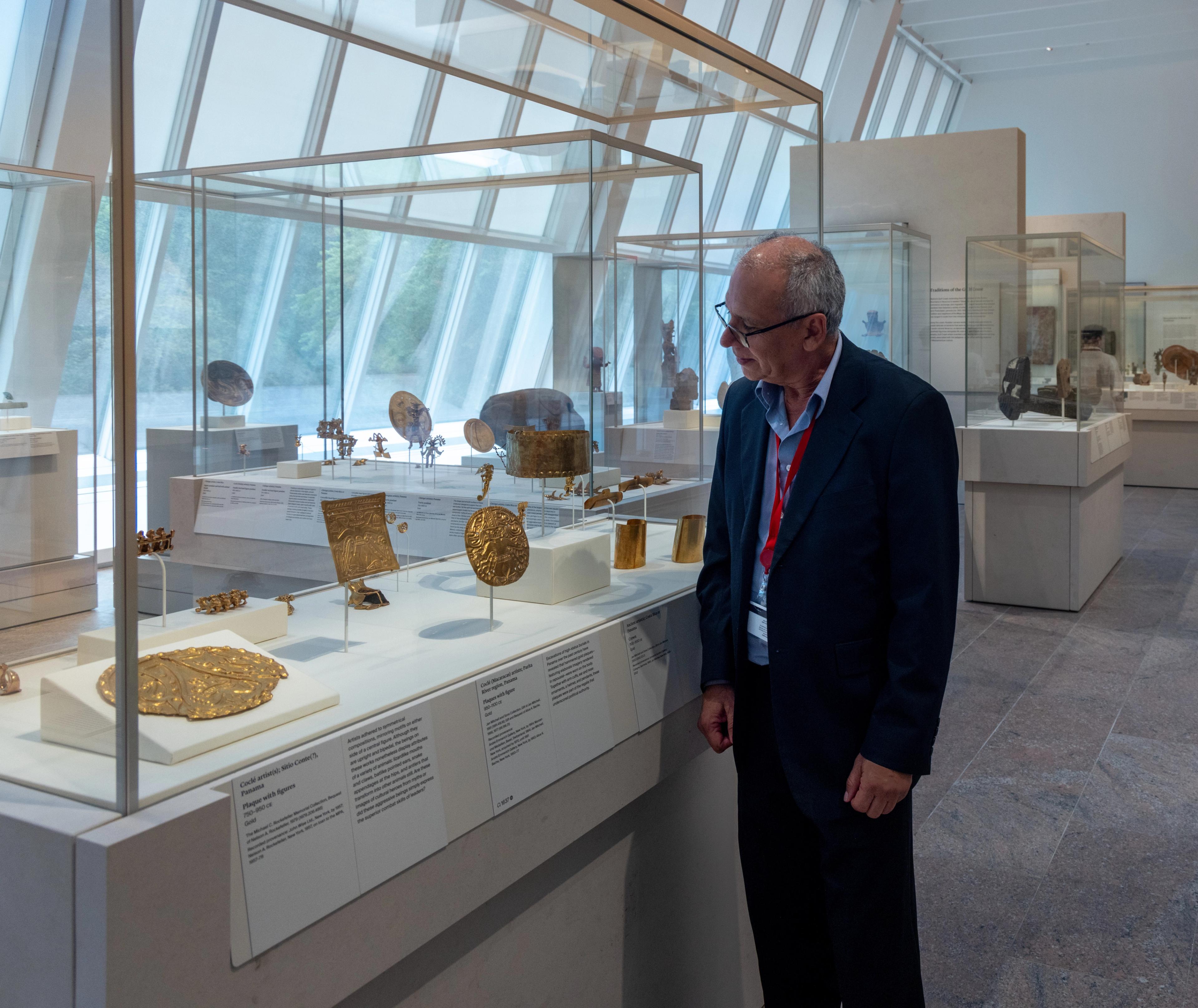 Francisco Corrales Ulloa looking at a gold plaque in the Arts of the Ancient Americas galleries