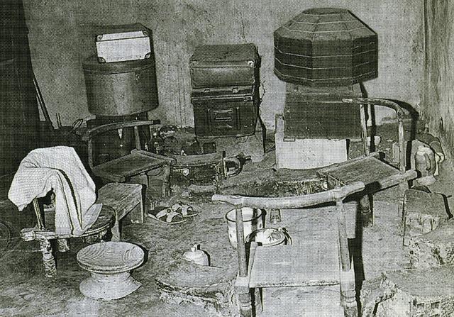 Ancestral shrine with four chairs and boxes in the background