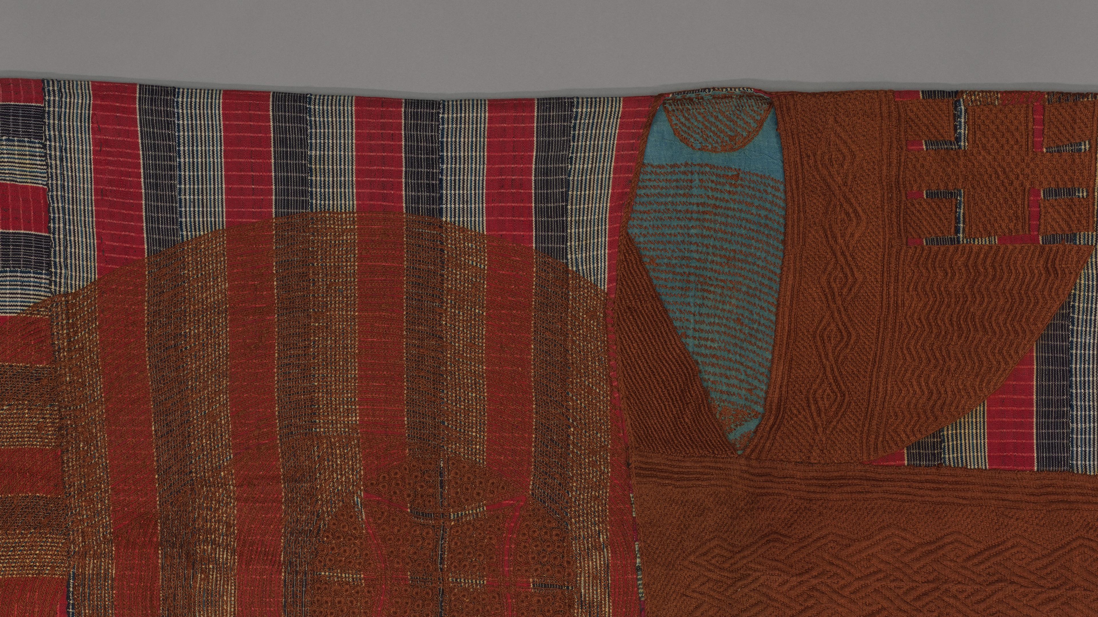 Detail of a striped robe in red, blue, and white with a central panel featuring abstract shapes and patterns.