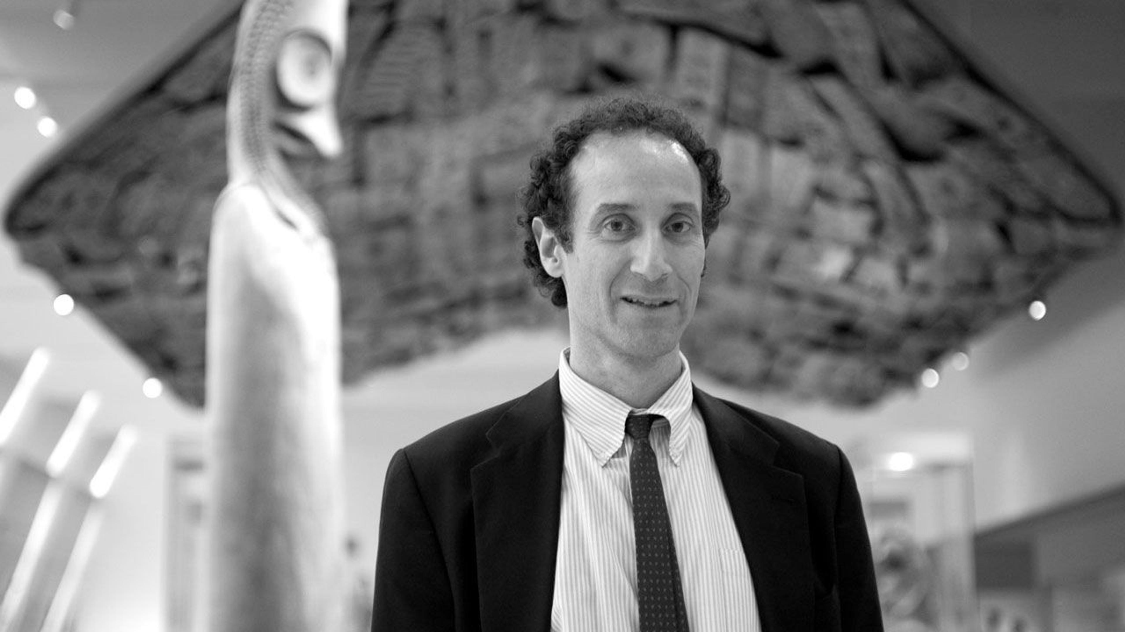 Black and white photograph of exhibition designer Dan Kershaw in The Met galleries