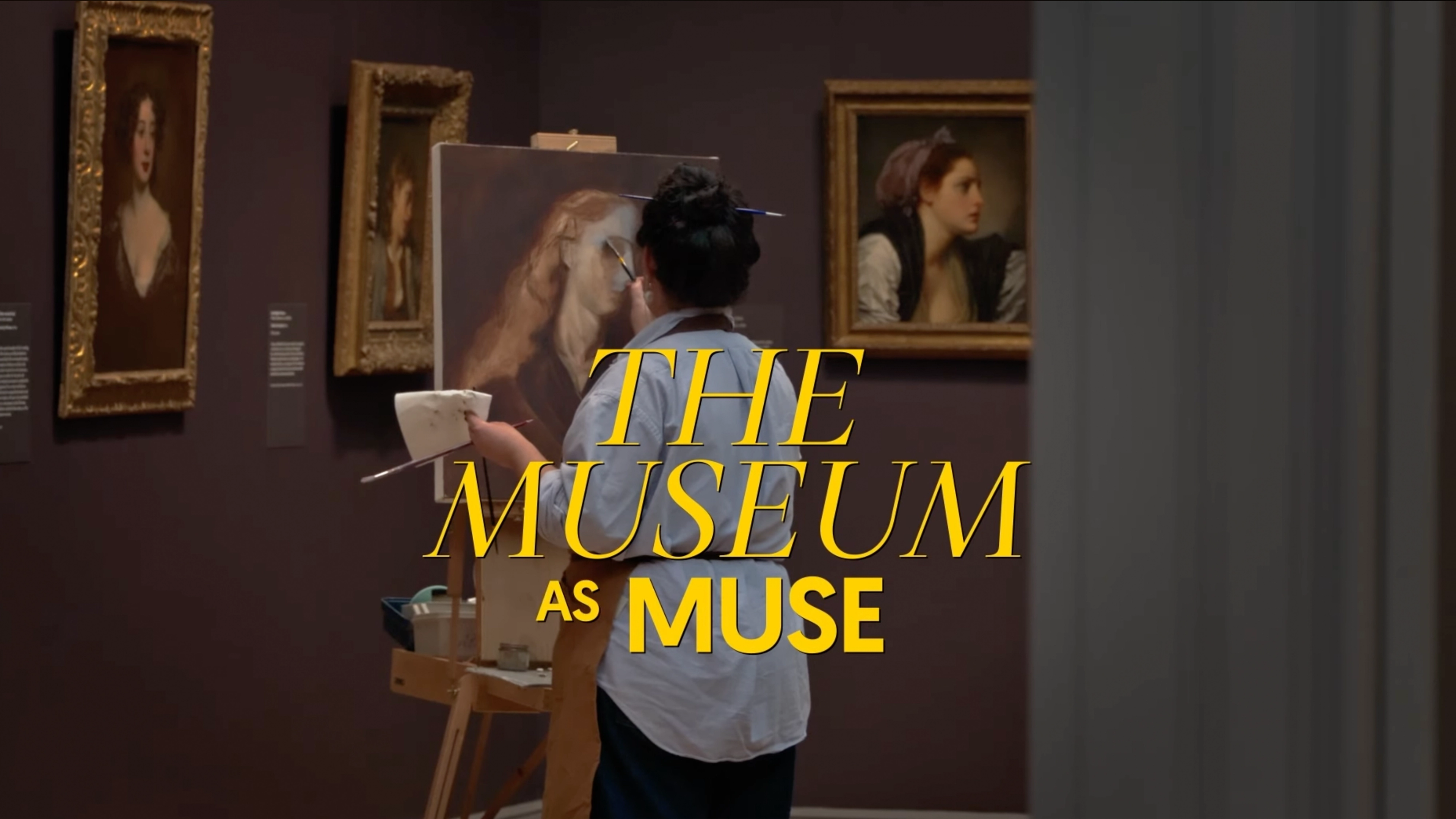 In a dim museum gallery, an artist stands at an easel painting a large portrait on canvas, holding a palette. Framed portraits hang on the dark wall behind them. Bold yellow text over the scene reads ‘THE MUSEUM AS MUSE.’