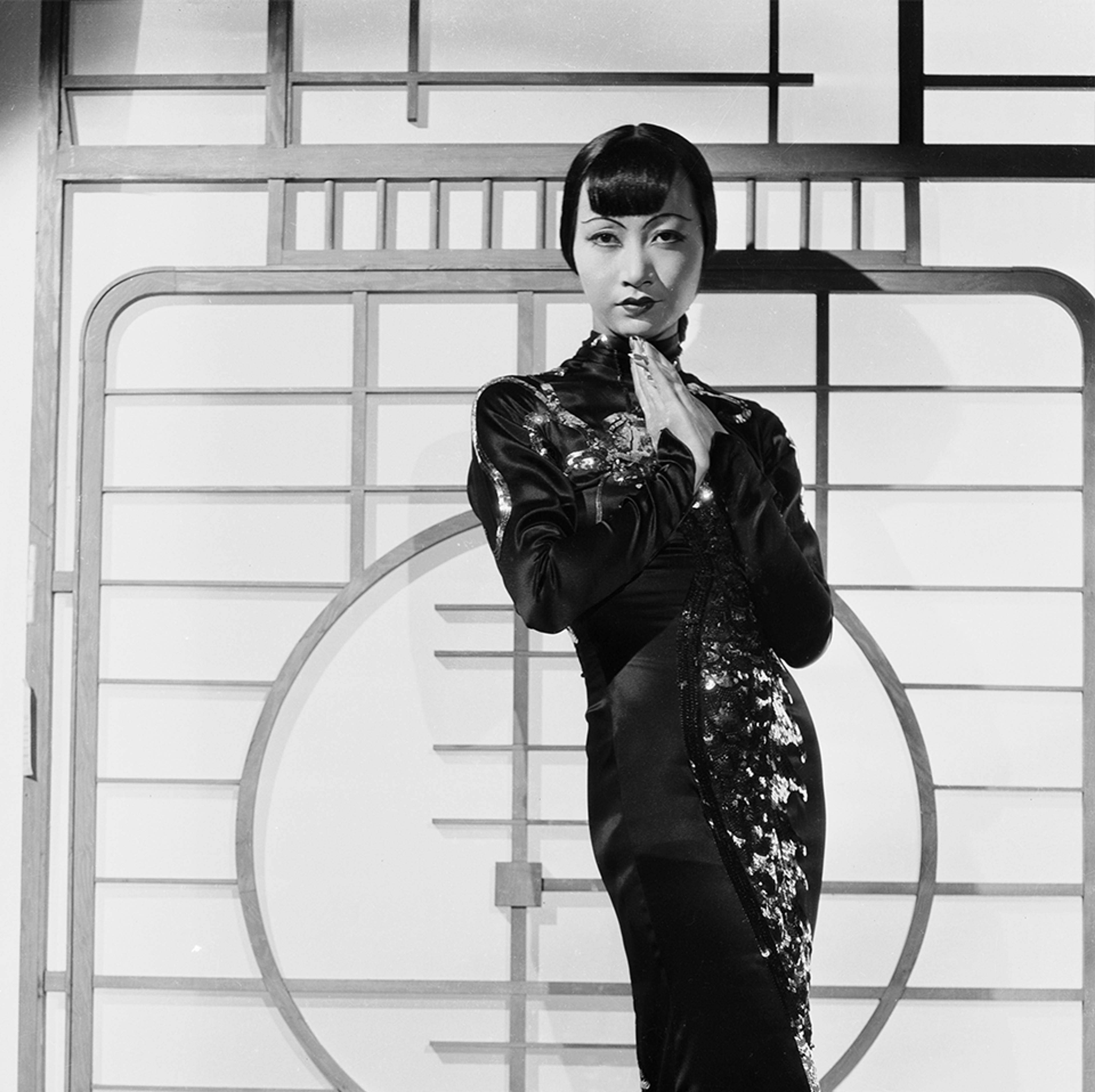 Black and white photo of woman posting where wearing a tradition Asian style dress.