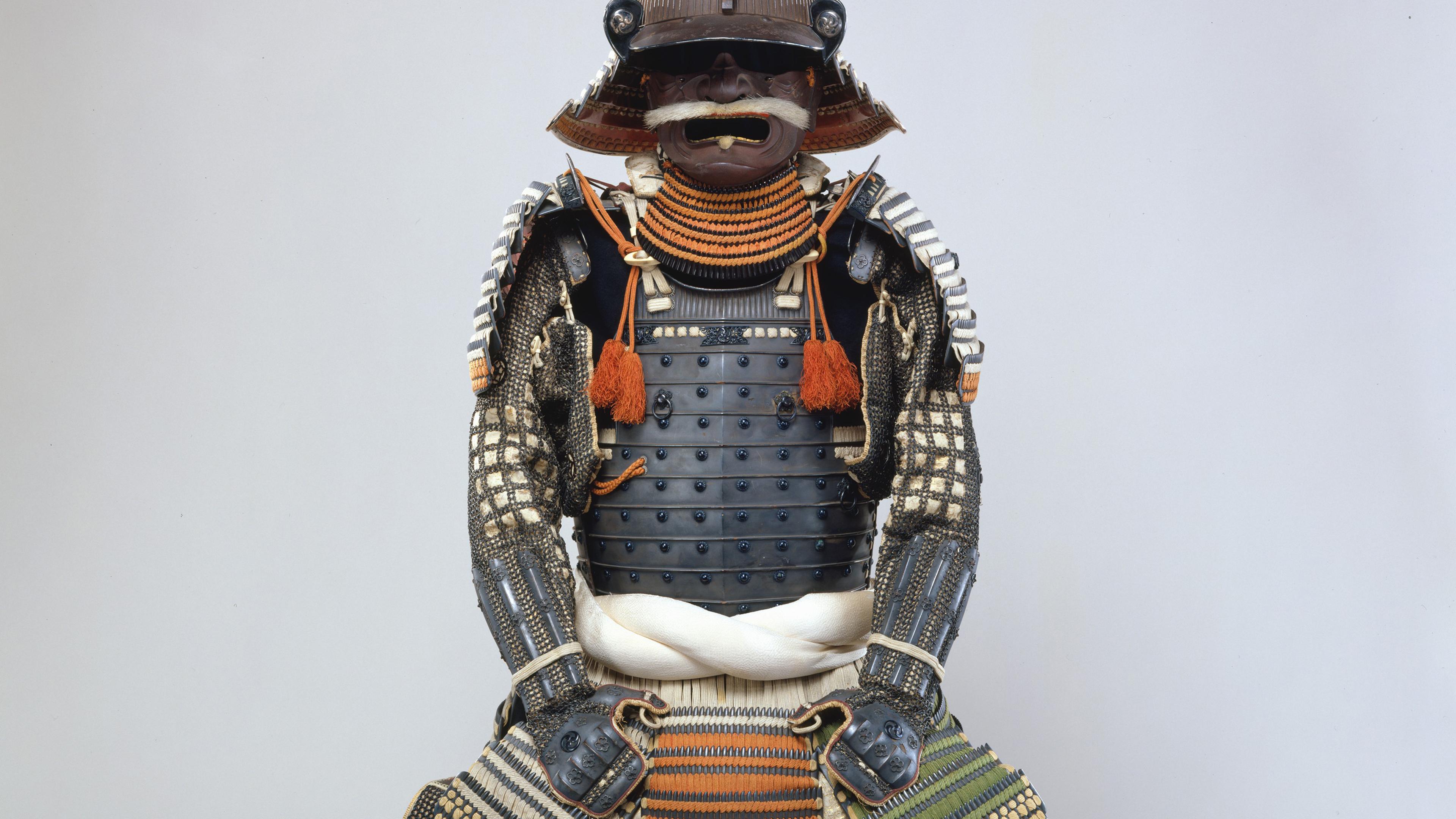 Image of Japanese armor. It features a kusazuri (skirt) with an extremely rare color scheme of silk lacings in red, yellowish-green, black, and white. The mon (heraldic badge), in the form of three whirling commas (mitsudomoe mon).