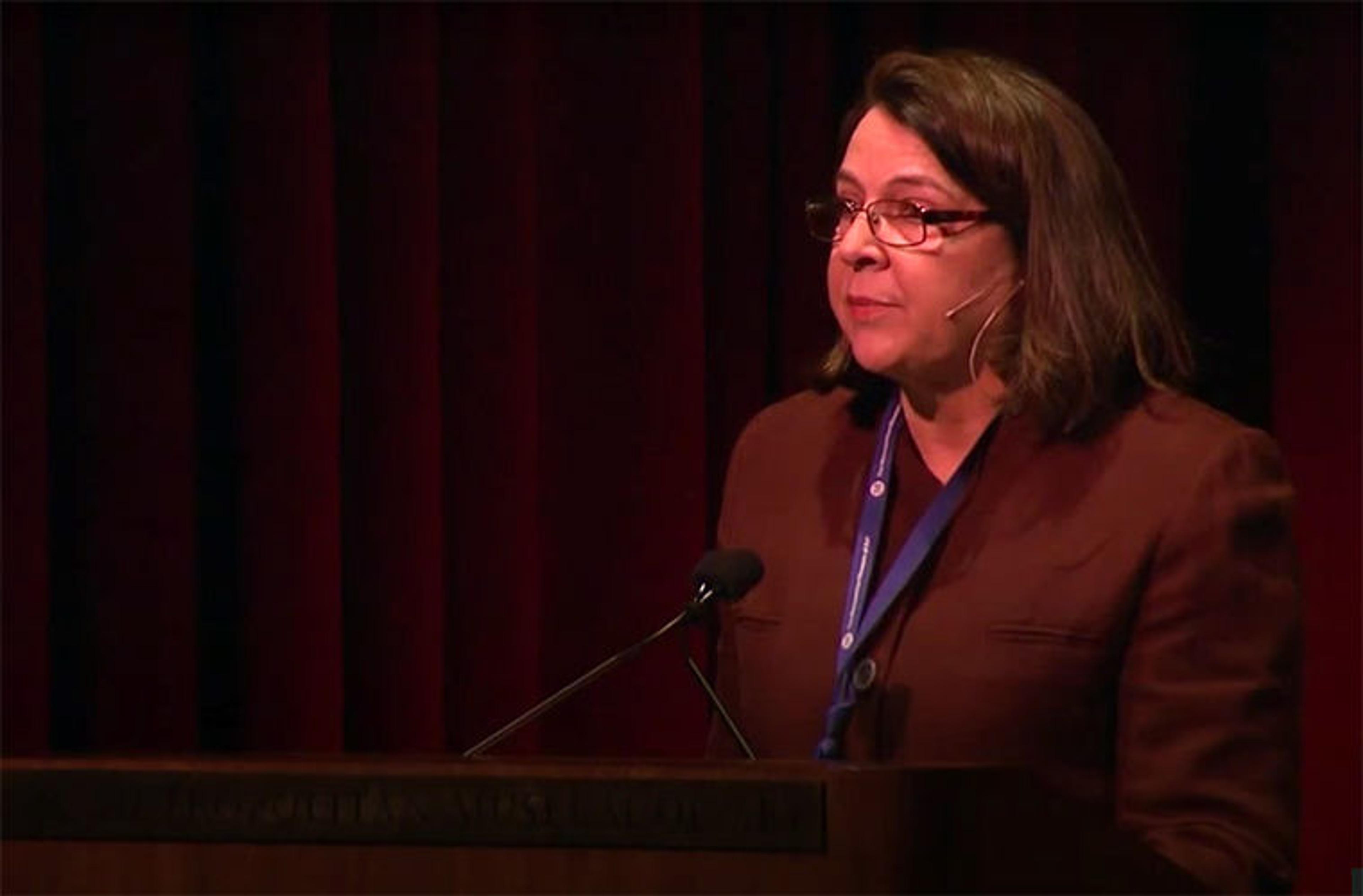 A Met curator speaking at a podium