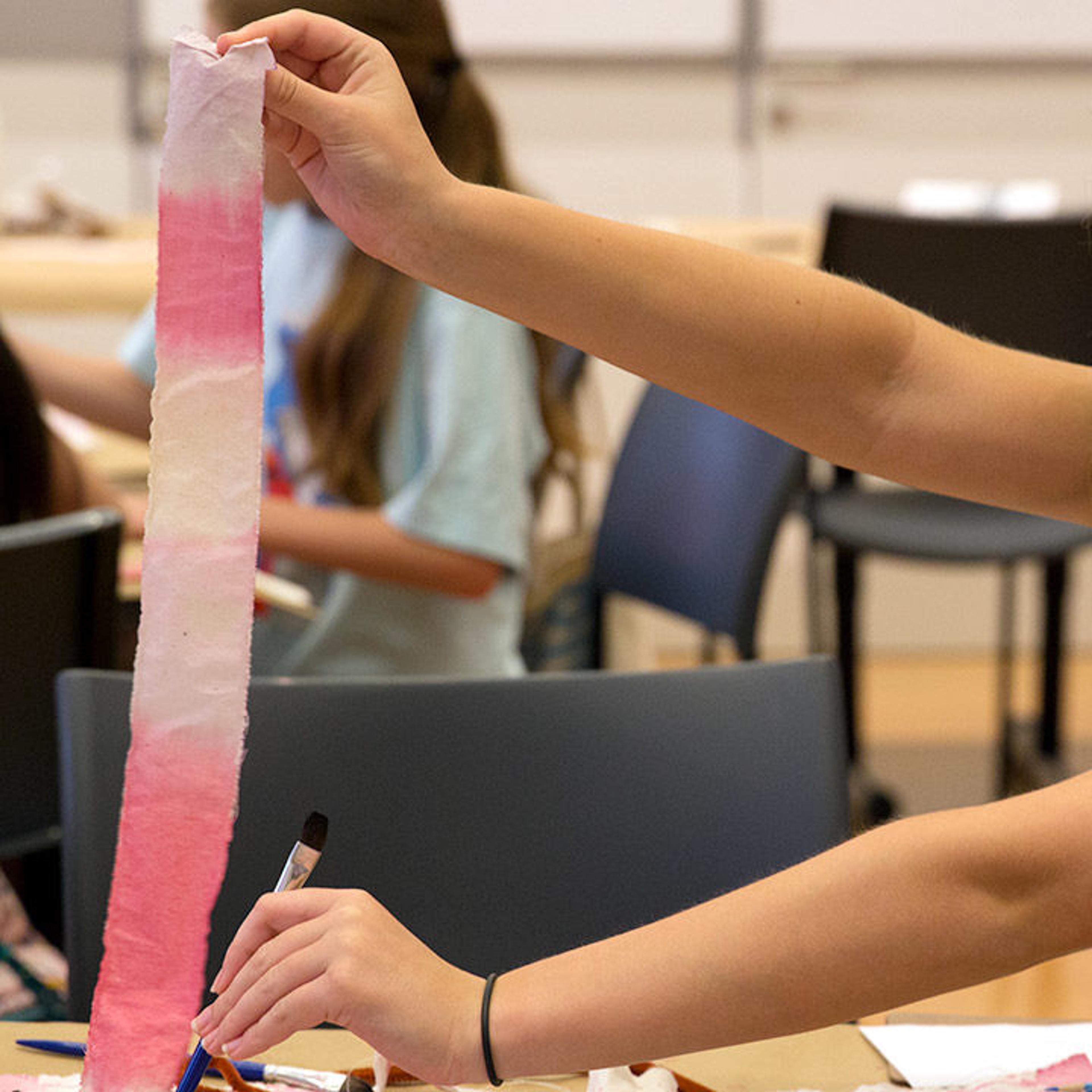 Teen colors strip of muslin cloth with dye made from fruits and vegetables.