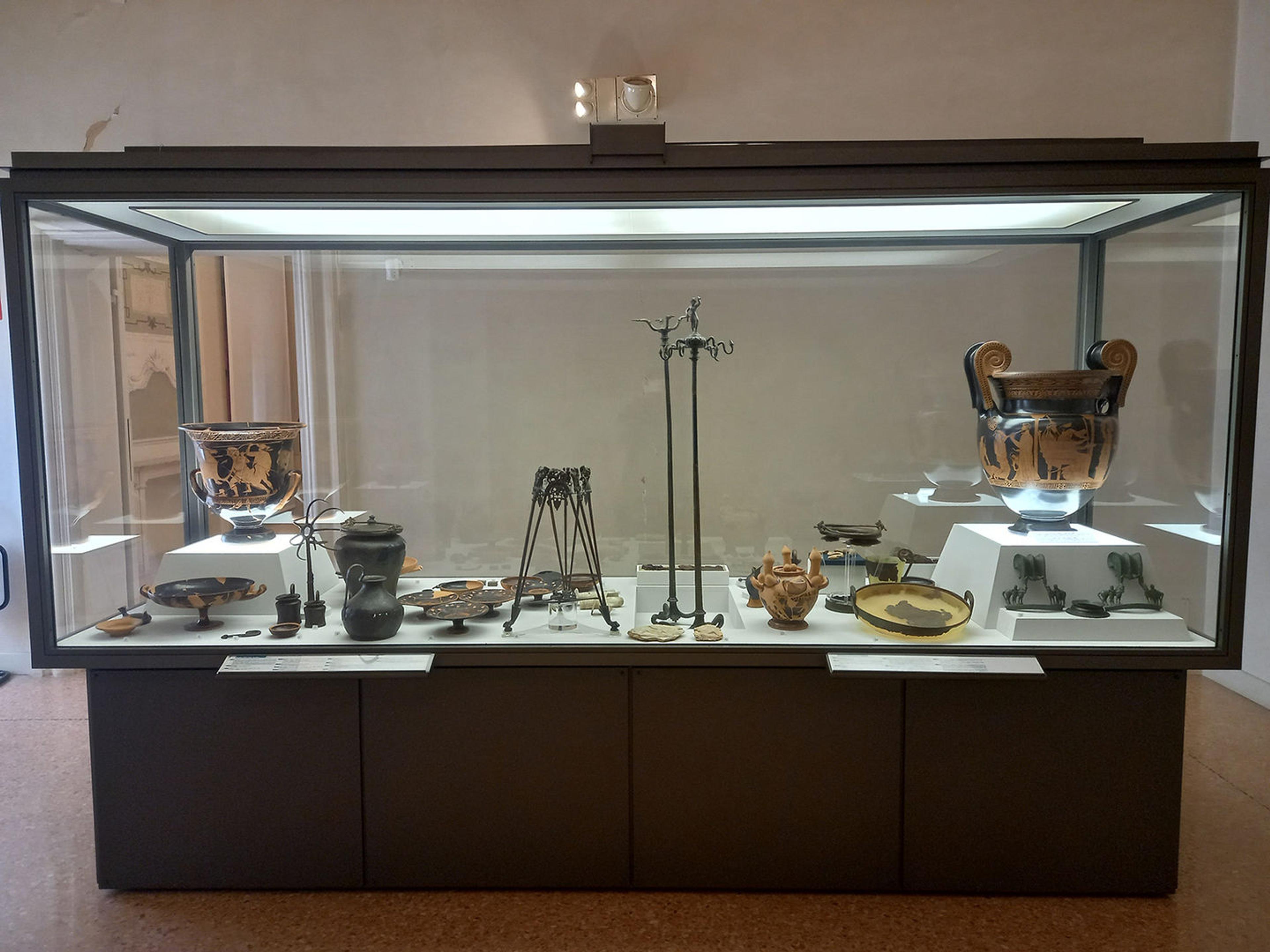 Glass display case showing the contents of Tomb 128 at Spina, including the volute krater at far right of the case.