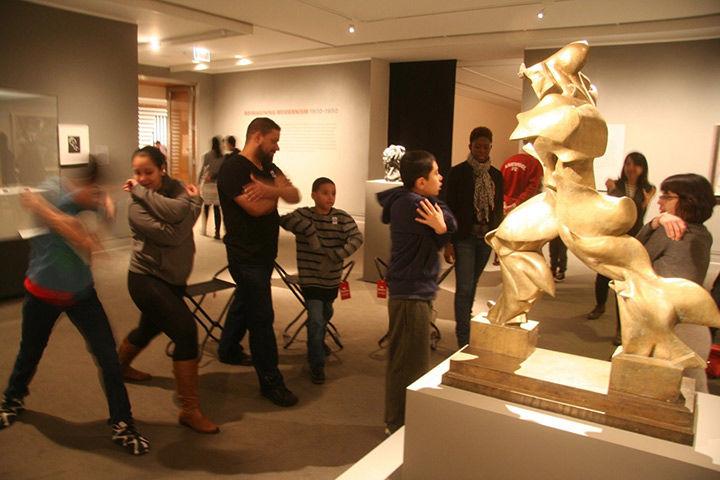 A group of visitors pose like a sculpture