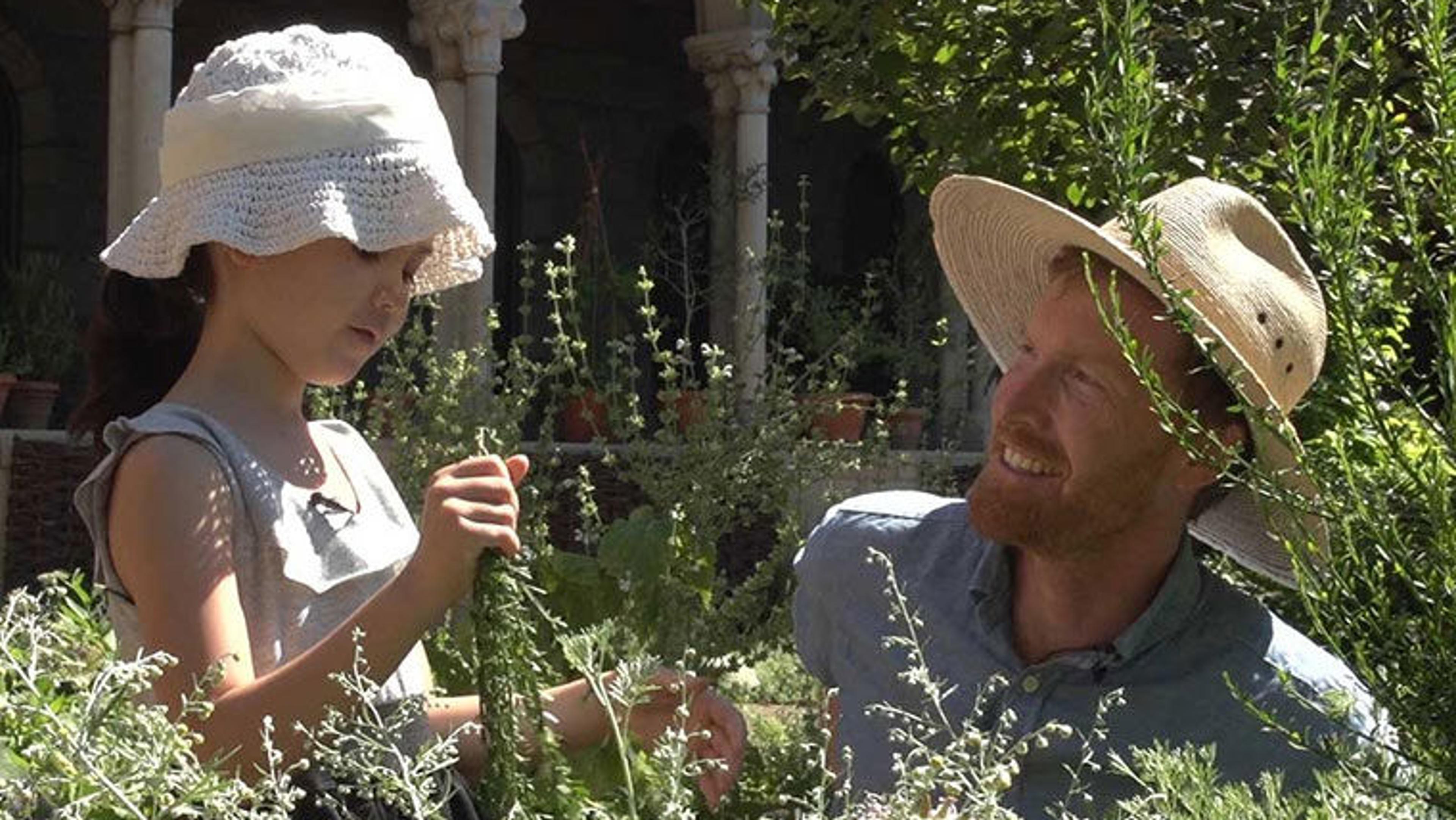 A Met horticulturalist and a child in a garden at The Met Cloisters