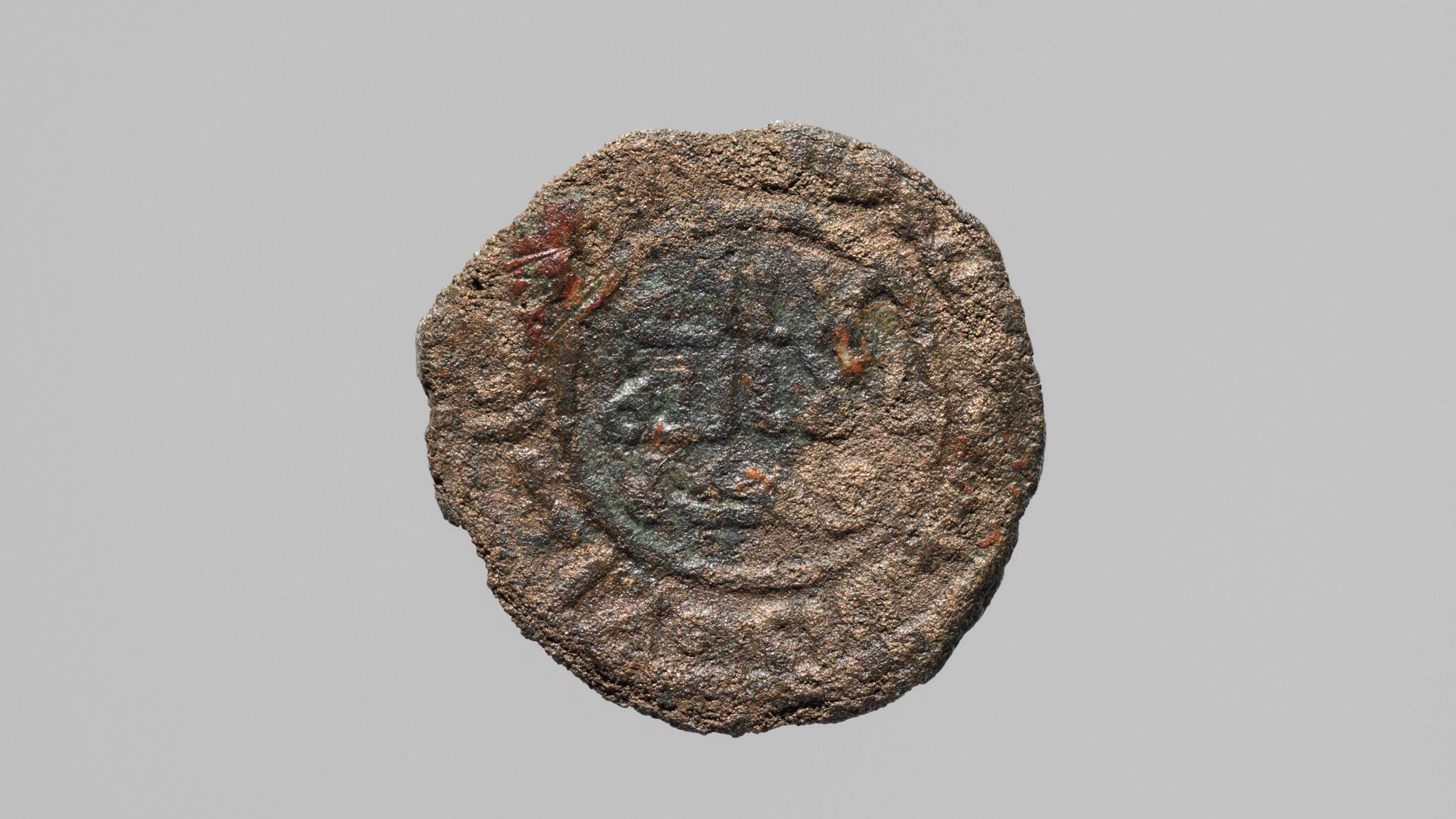 A textured and discolored ancient coin.