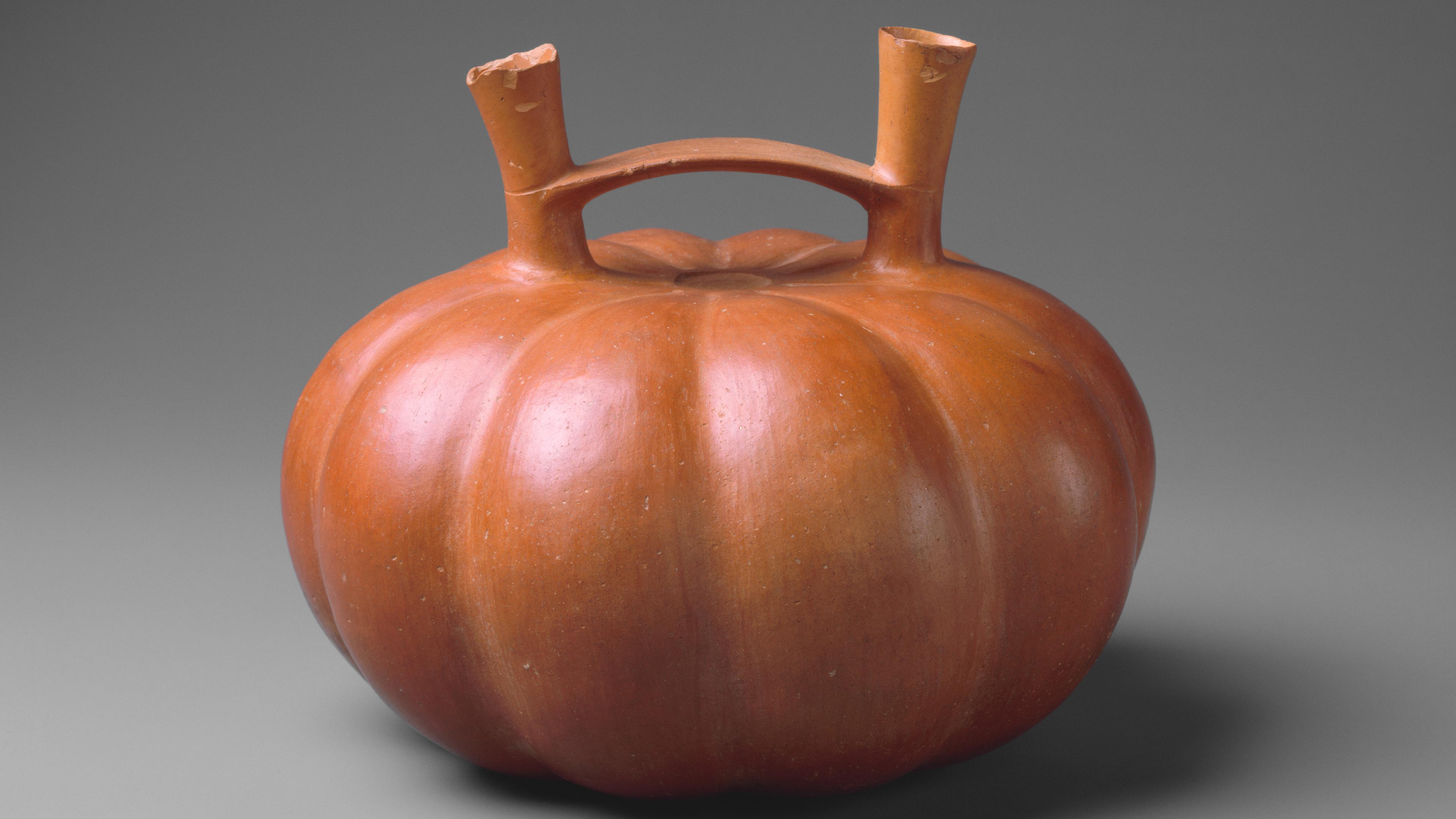 Orange, pumpkin-shaped vessel with two spouts