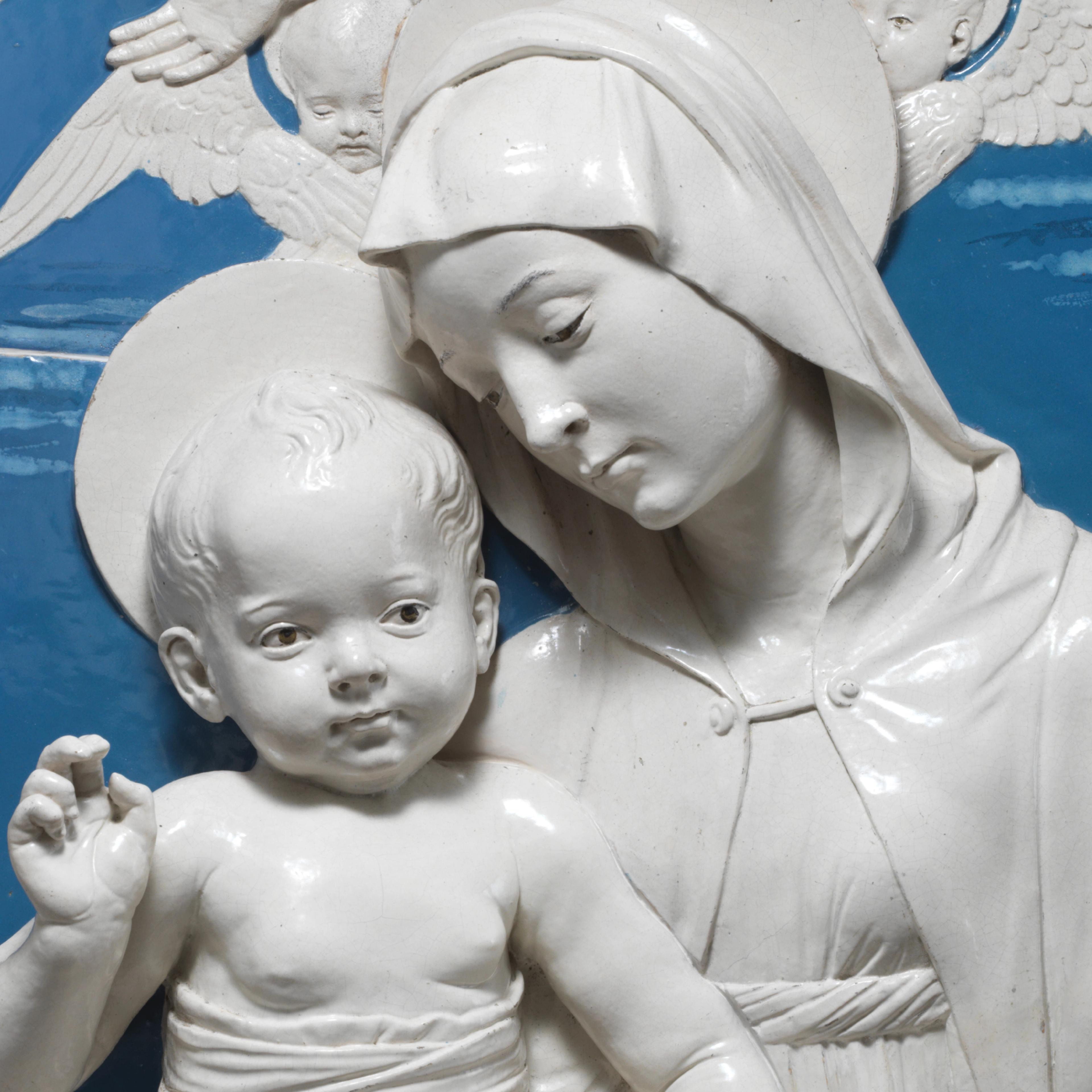 Sculpture of woman and child against blue background