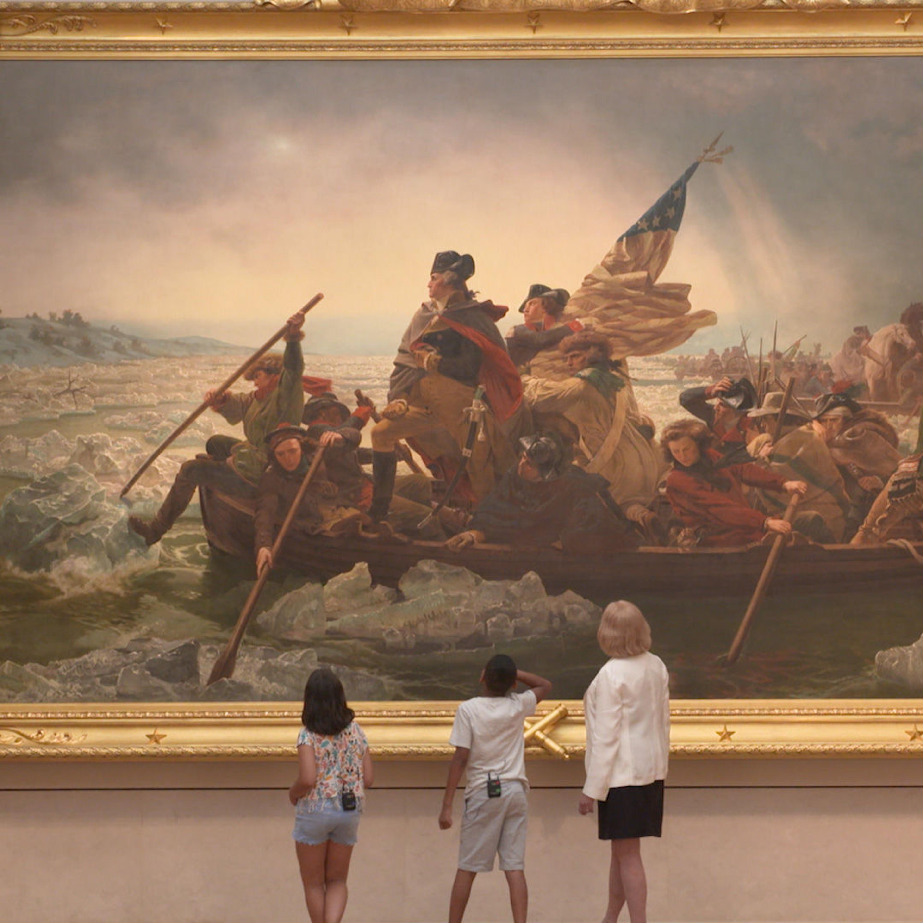 Adult curator Betsy Kornhauser and two kids named Gaia and Carmelo look at the painting Washington Crossing the Delaware at The Met. Their small figures are dwarfed by the large painting.
