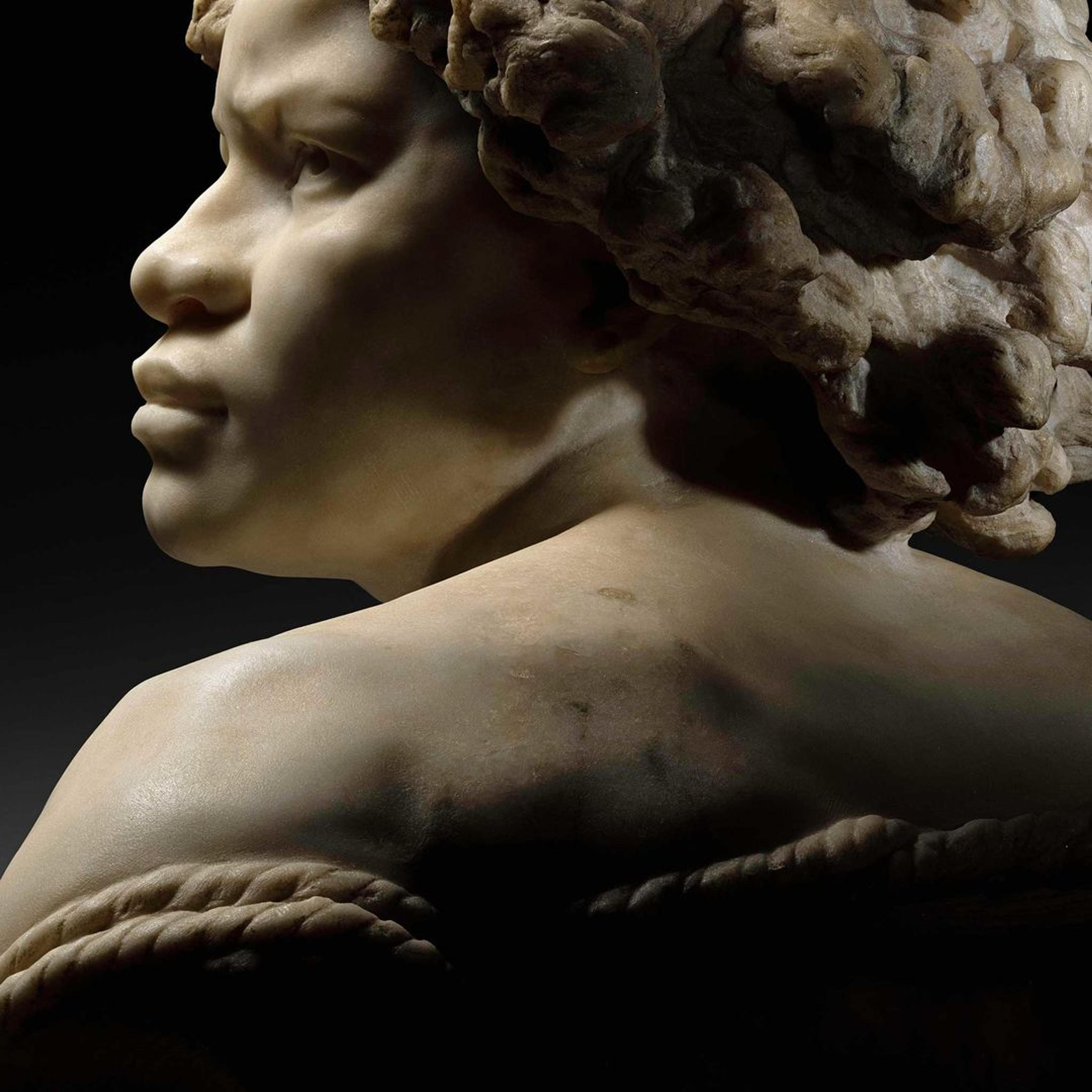 A high-contrast view of Jean-Baptiste Carpeaux's "Why Born Enslaved!" from behind with her profile showing